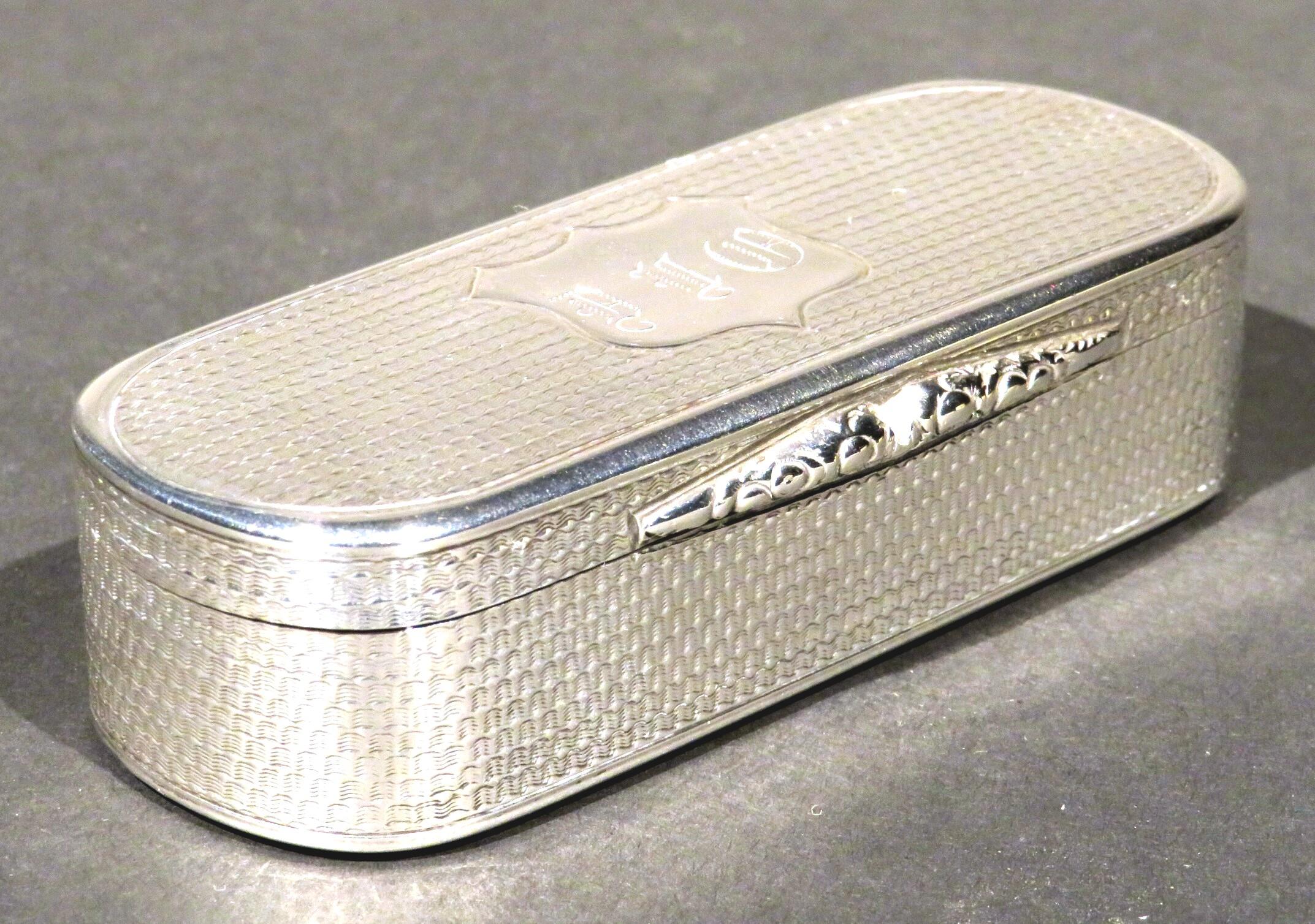 A very good 19th century Victorian sterling silver snuff box of oblong form, showing a hinged lid engraved with machined undulating wavy motifs, centred by a monogrammed shield-shaped cartouche, opening to a richly gilded interior with both the lid