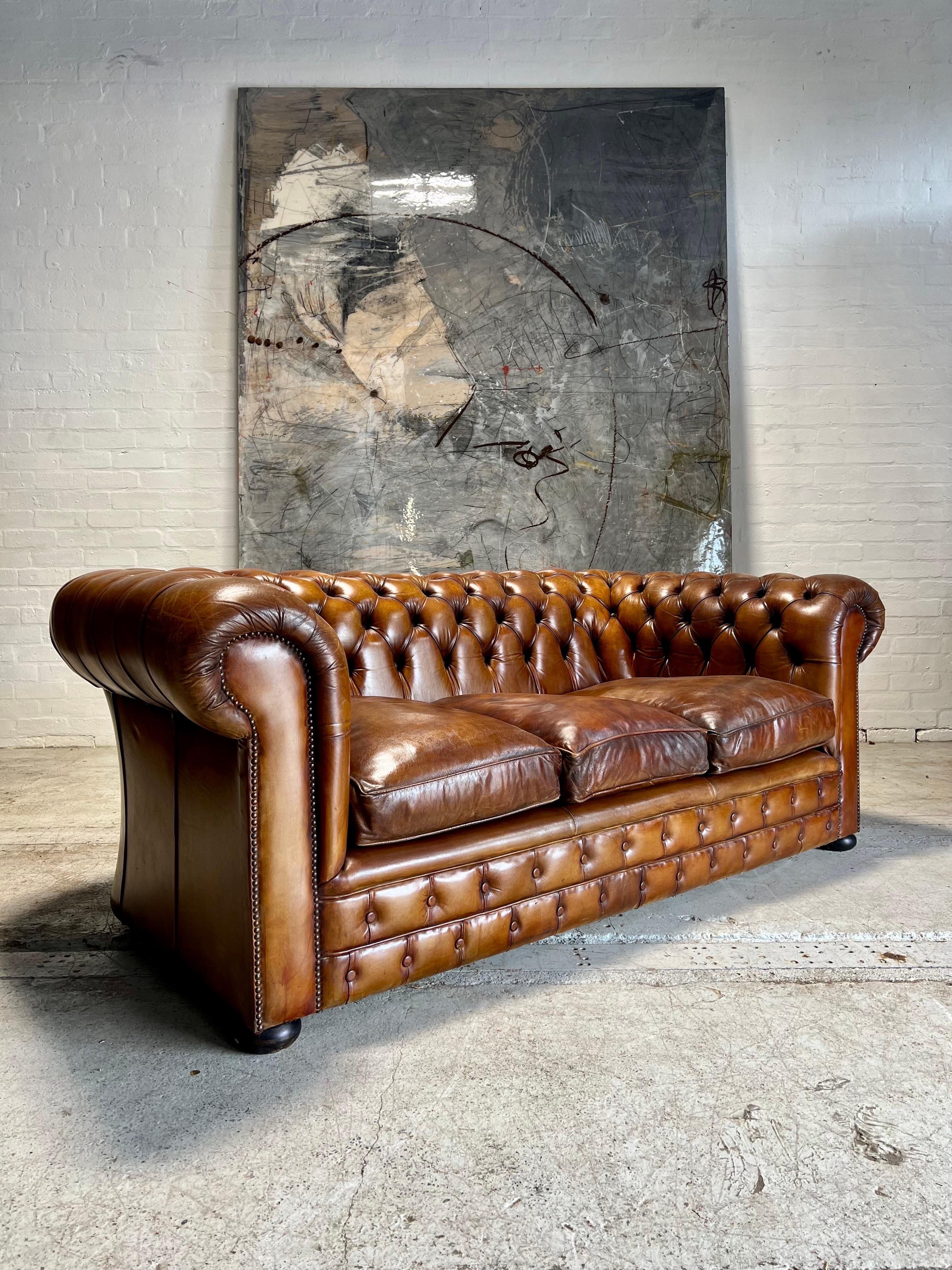 This really is an exceptional MidC leather chesterfield sofa. 

Beautiful Whiskey hand dyed leathers, the colouring is very rich with natural patina.

A very robust piece with down & feather cushion inners.