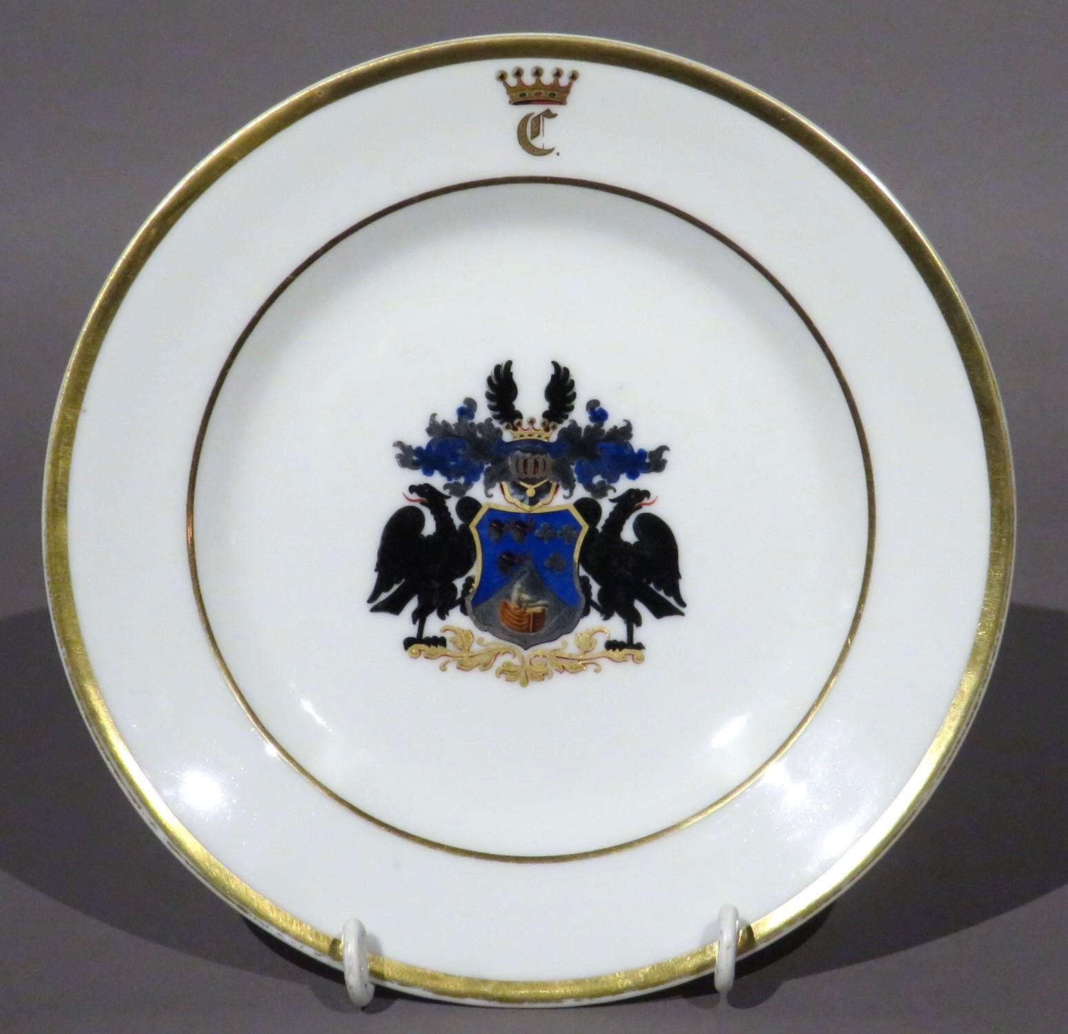 Both showing a central field decorated with striking hand painted Heraldic crests, the rims decorated with hand painted Baronial coronets within gilt edged detail. The reverse of each plate inscribed with a dedication denoting Baronial titles