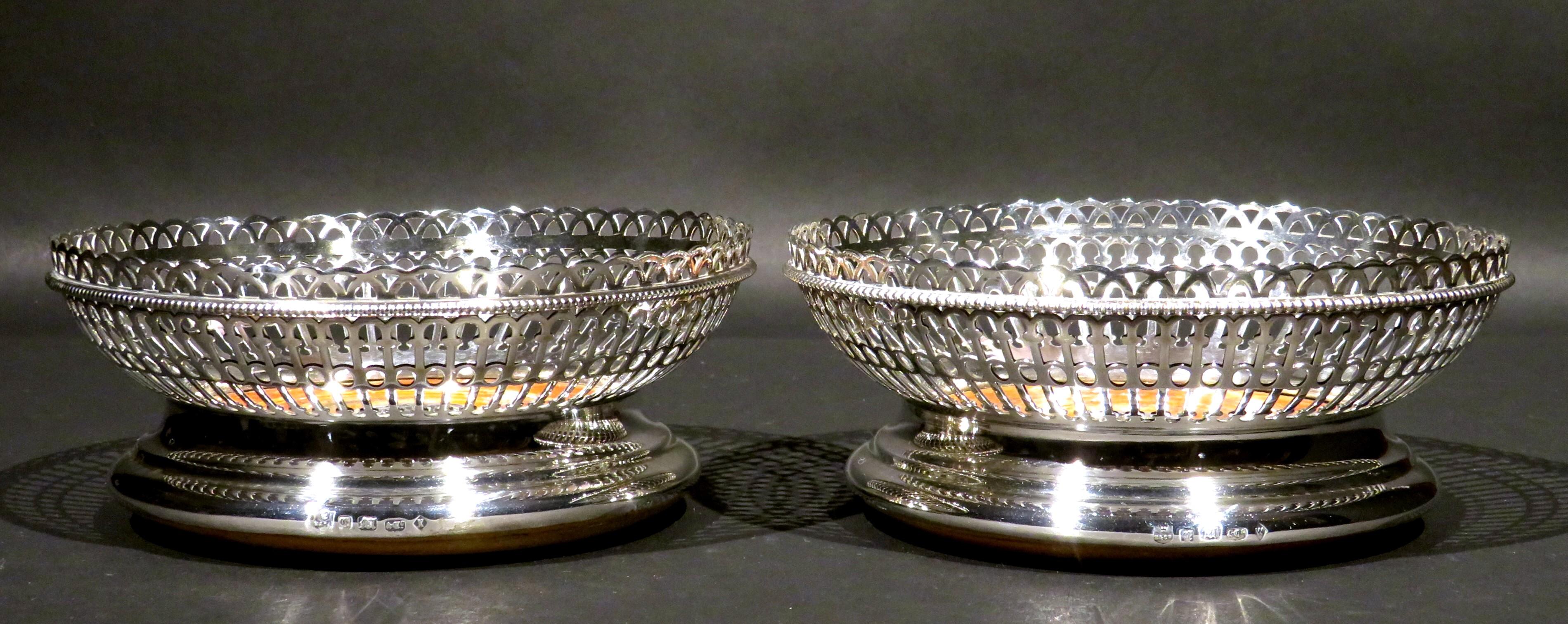 A very handsome pair of mid-19th century silver plated wine bottle coasters by Elkington & Company of London, showing swelled and pierced latticework bodies rising from turned satinwood bases centred by silver plated roundels engraved with stags
