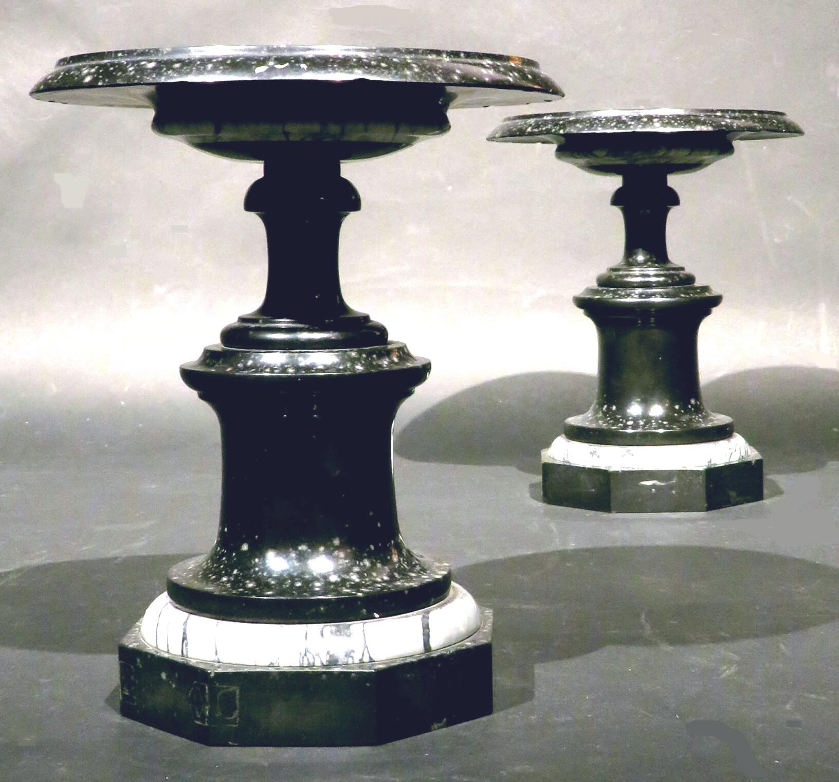 A striking pair of Art Deco fossilized black marble tazzas showing dished circular plateaus centred with black & grey striated marble roundels, raised on turned columns atop octagonal sided bases decorated with black & grey striated marble mouldings.