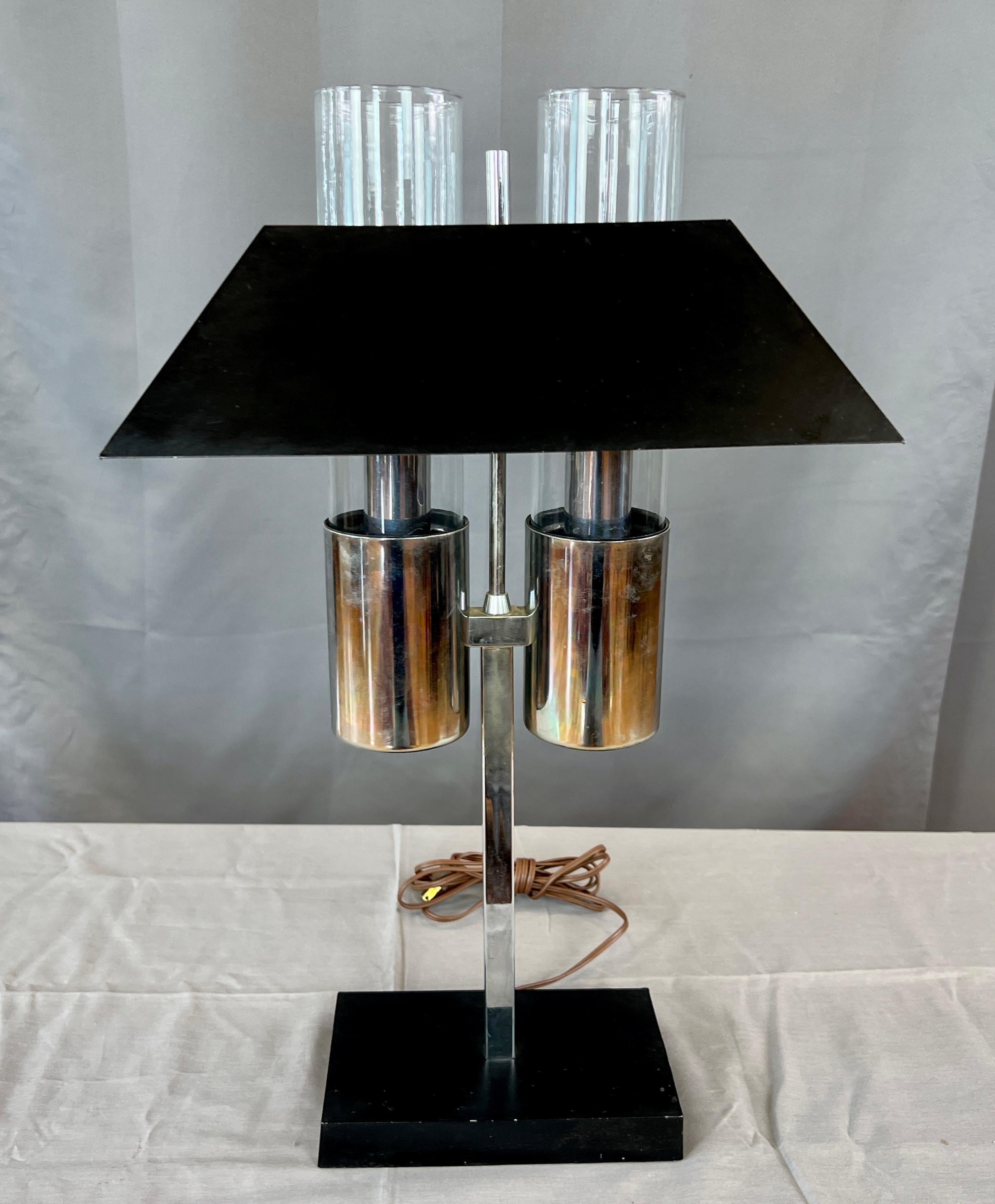 What a very handsome bankers lamp, that's chrome and black metal imported from Italy by Raymor, circa 1960s.
Black rectangular base, and from it's middle a chrome square pole that then holds the double chimney lights. Bottom
half is a chrome