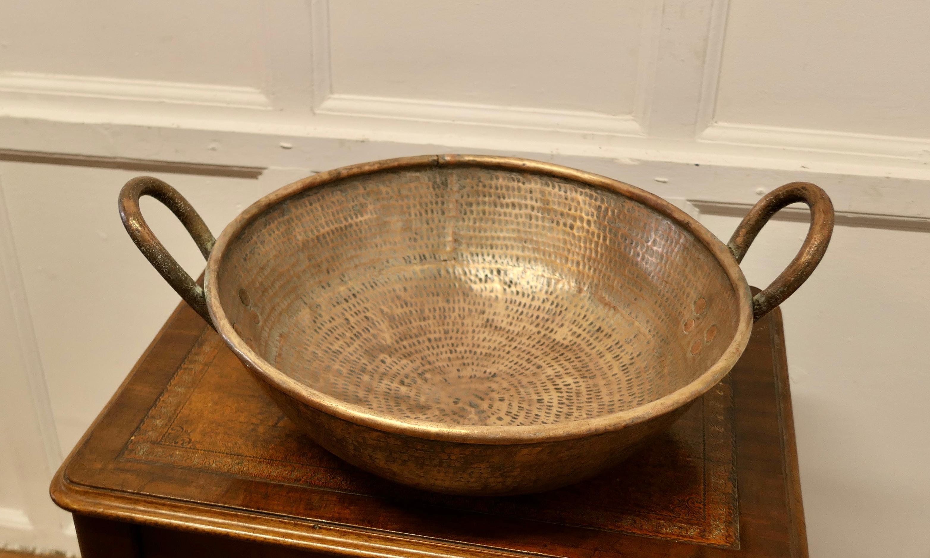 Very Heavy Hand Beaten Brass Dish with Handles

A very heavy and well made piece, the dish has a gentle upward sweep to the edges, and it has a rolled top and very thick strong riveted handles
The dish is 9” high to the top of the handles and 17”