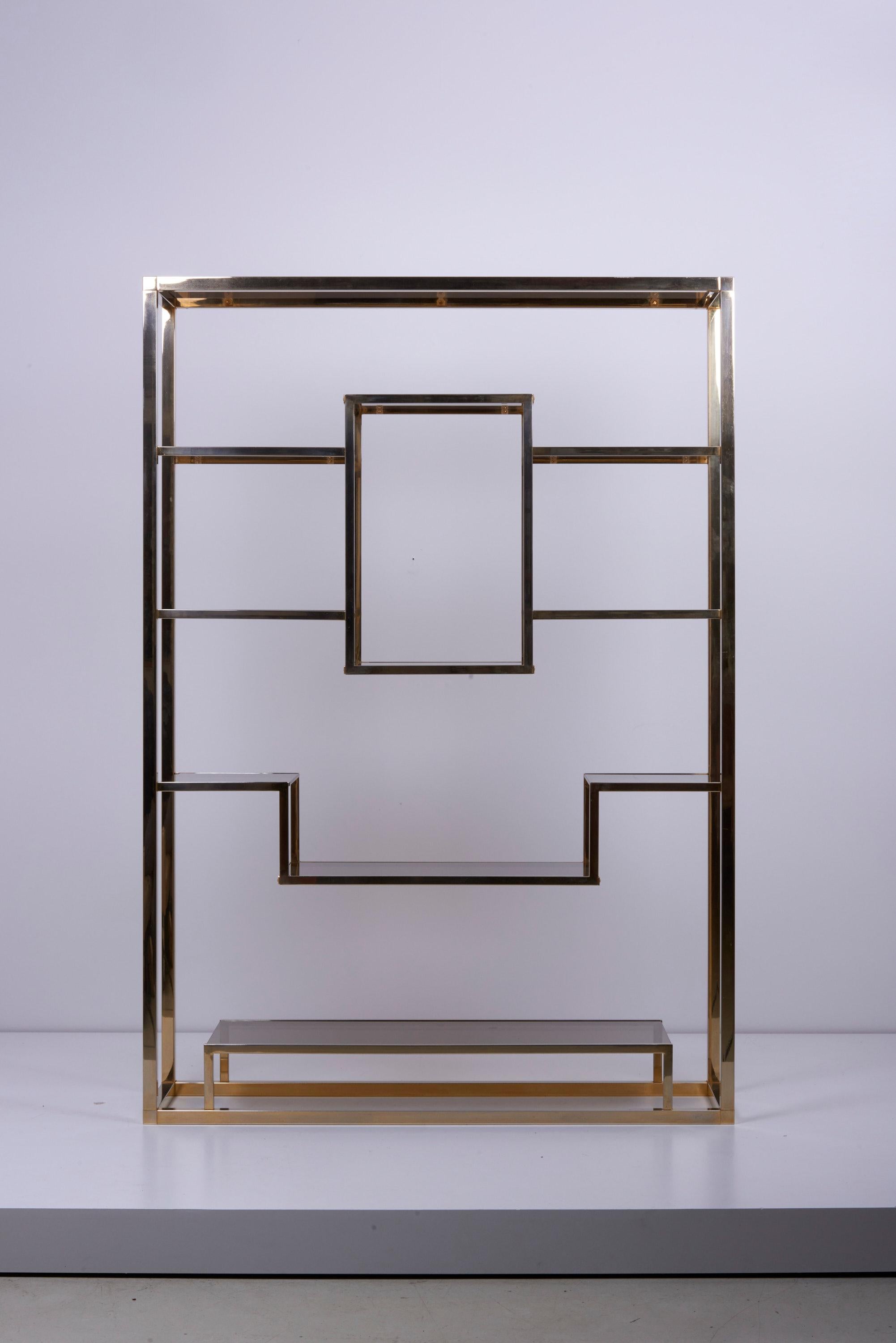 Very huge and rare brass and tinted glass bookshelf or étagère in the style of Romeo Rega. The étagère is in good condition and an eyecatcher for every room.