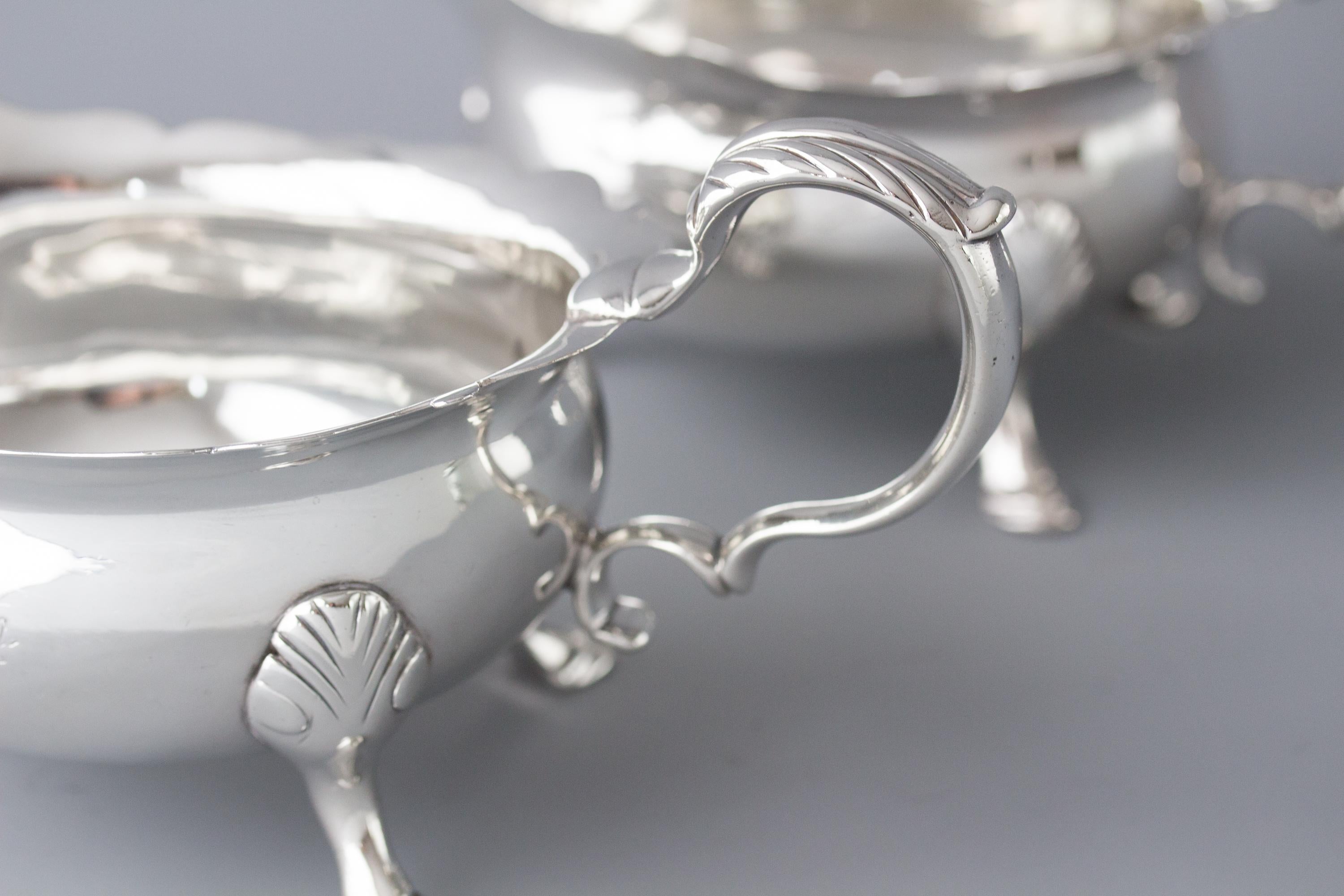 A very fine pair of George II silver sauce boats, by Nicholas Sprimont, London 1742. Of plain, large oval form, raised to a wavy rim with an acanthus mounted scrolling handle. Both engraved to the side with identical crests. (See pictures) All
