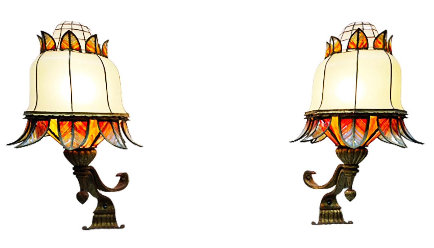 Very impressive stained glass wall lamps, 95 cm high

Stained glass lamps which are very large and imposing. A flower model with wrought iron gilded wall brackets. The stained glass is made of curved glass made in the early 20th century in France.