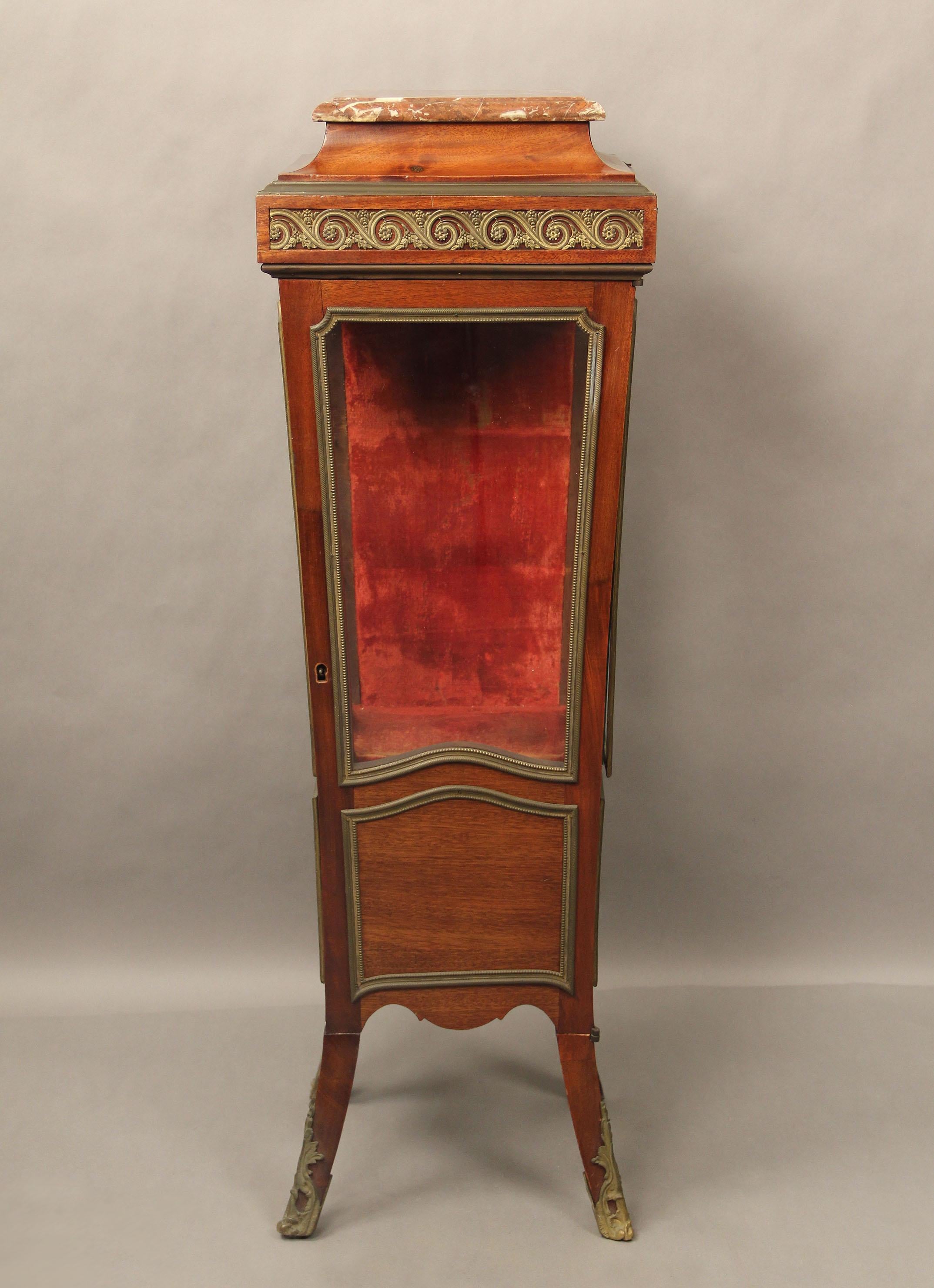 A very interesting late 19th century gilt bronze mounted transitional style vitrine pedestal

The square rouge marble top above a frieze, a single central door opens to a red velvet interior with a hidden bottom compartment.

Details:
Height 43