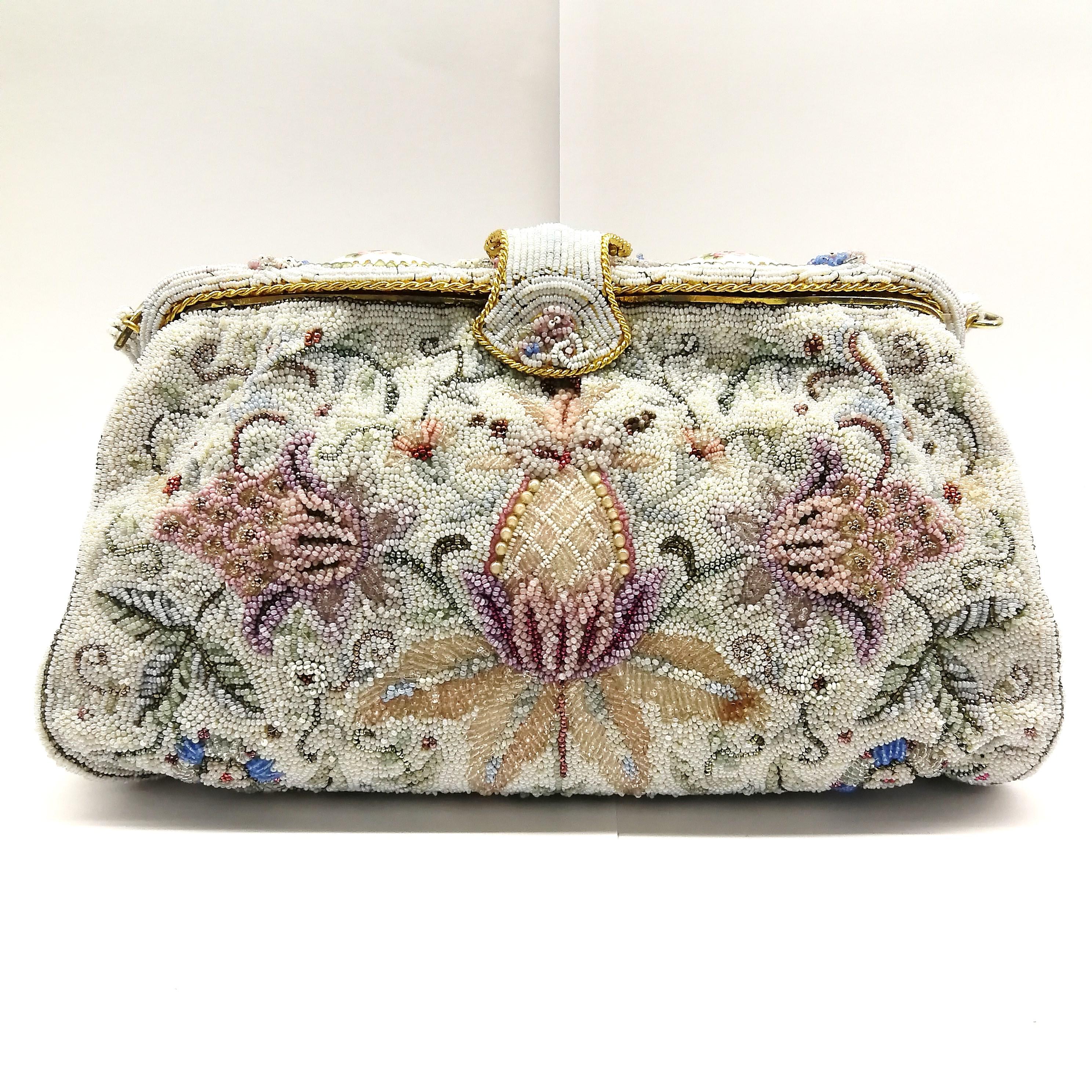 An exquisite hand beaded handbag, made in Paris in the 1950s, with fine floral patterns, depicting blossoms, leaves and small flowers, in soft delicate pastels, highlighted with metallic bronze, mint , gold and silver micro beads. It has a heavily