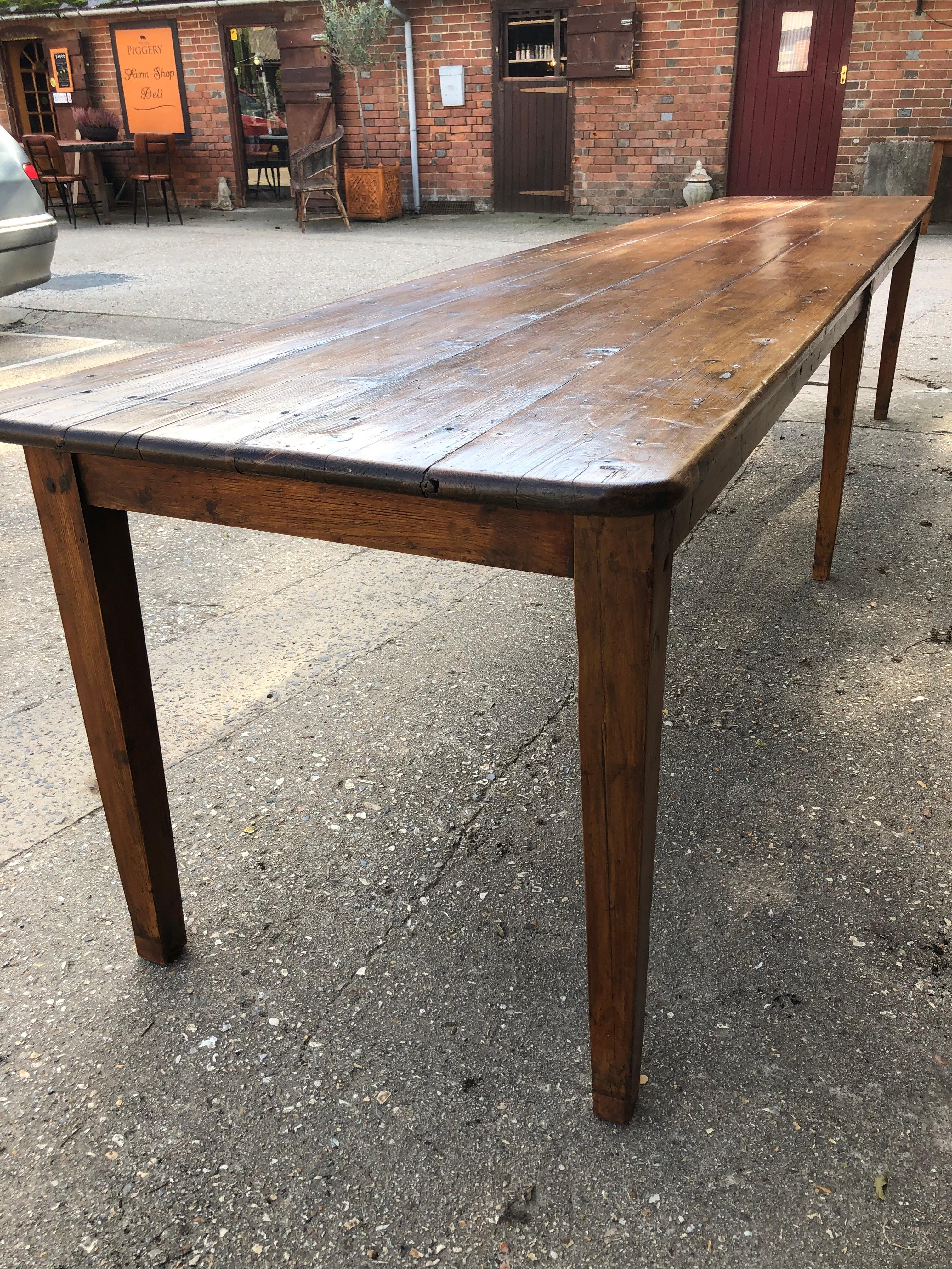 Very long French farmhouse pine harvest or dining table on six square tapering legs of good color and patina.