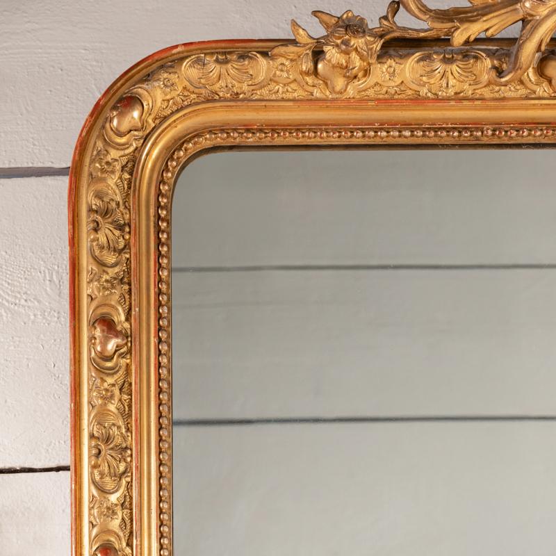 Très grand miroir en bois doré sculpté de grands godrons, d'un petit fronton de style Régence, de rinceaux et de fleurs.
Très belle dorure d'origine, miroir ancien, plancher en bois.
Période Napoléon III - France 19ème siècle

Hauteur 178 cm - 70,08