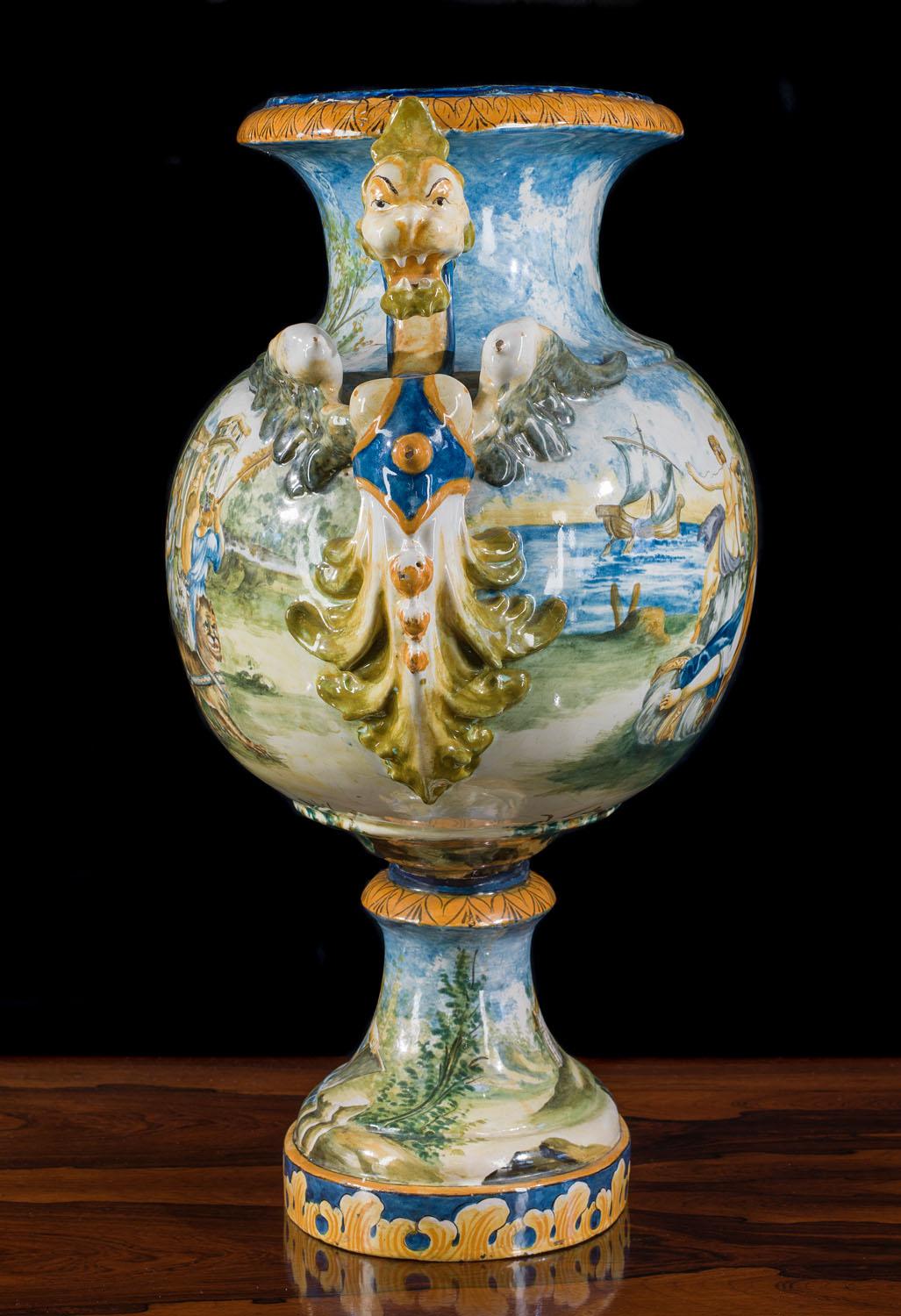 A very large 19th century twin handled maiolica vase in the form of a wine krater. The exquisite hand painted decoration includes two central cartouches, one depicting Bacchus and Ariadne reclining within an allegorical scene. Bacchus loosely hold