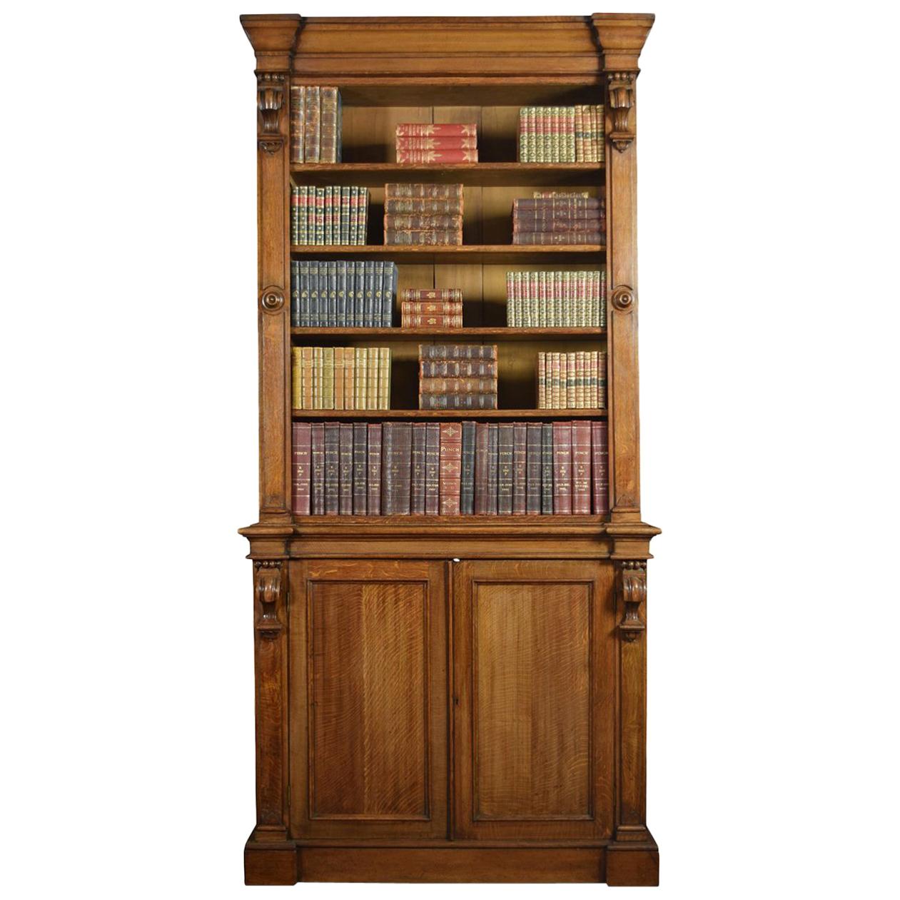 19th century oak bookcase with a flared cornice over a large open top bookcase with four adjustable shelves, the base section fitted with two panelled doors enclosing shelved interior. All raised up on plinth base
Dimensions:
Height 103.5