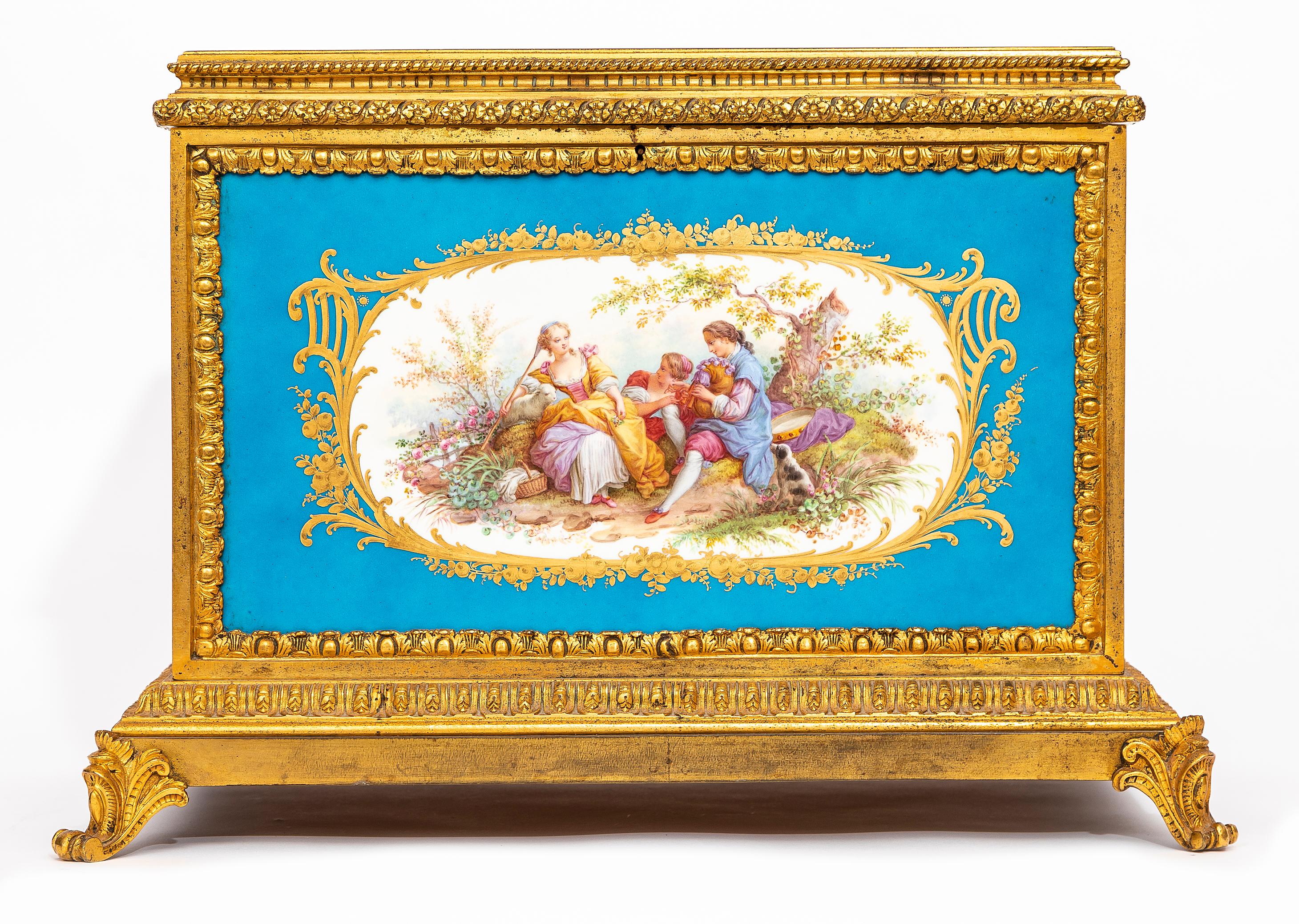 Très grande boîte en porcelaine de Sèvres à fond bleu céleste, montée en bronze doré, avec cartouches de scènes de Watteau, datant du XIXe siècle.  Cette boîte est composée d'un fond bleu céleste caractéristique de la porcelaine de Sèvres, une