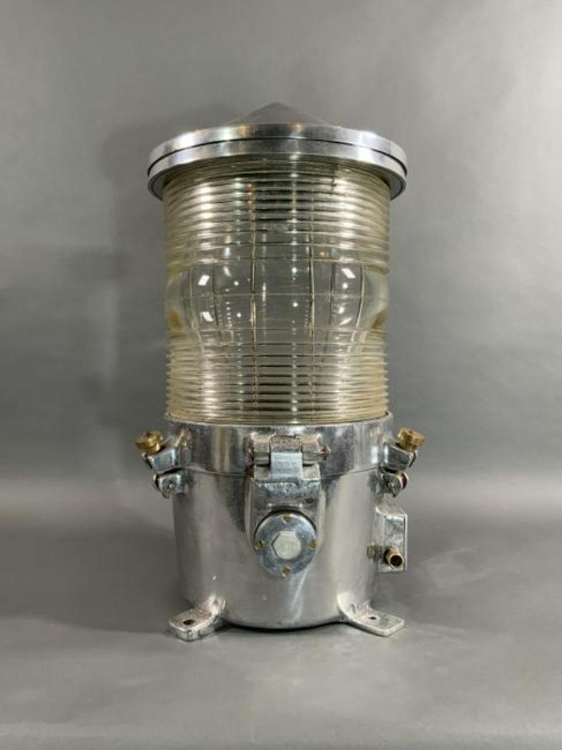 Beacon built by Stone Chance Navigational Aids. Exceptional piece of industrial lighting. Fresnel glass lens set into a sturdy aluminum housing. The drum lens is 12 inches tall. There are four angled mounting tabs at the base. Weight is 51 pounds.