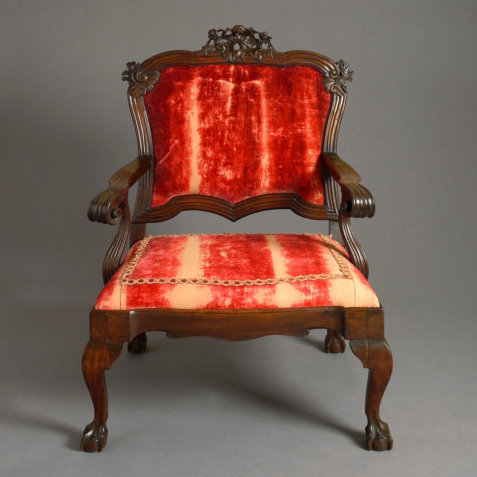 An 18th century Portuguese open armchair of large proportions, the cartouche shaped back with shell carved cresting and moulded frame leading down to the scrolled open arms above the drop-in seat with shaped rails and cabriole legs terminating in