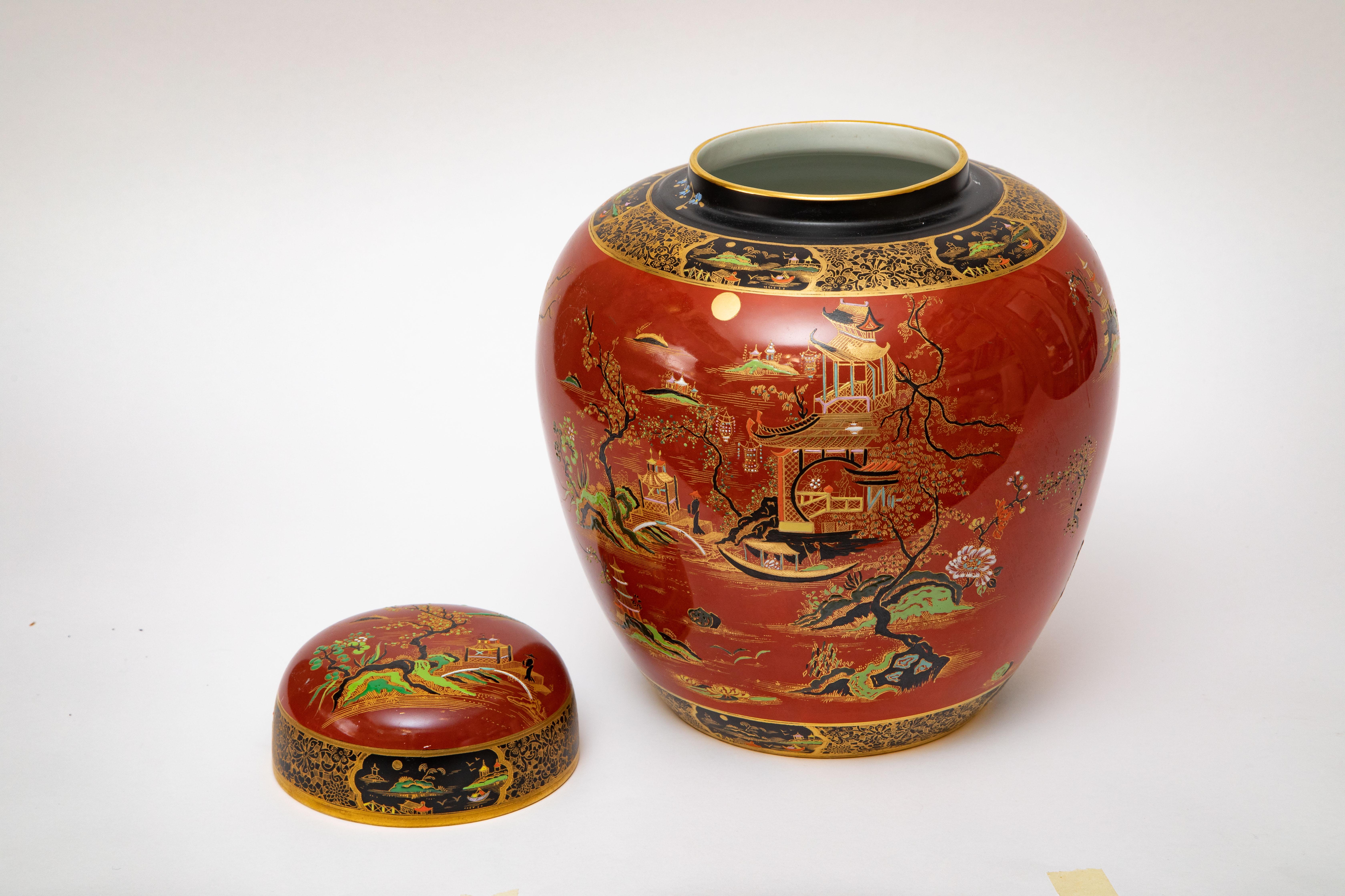 A large and impressive hand painted vase and cover from the re known studio of Carlton England. This Chinoiserie design features a variation of the Willow on a burnt orange background accented with black rims, bright greens and of course 24 karat