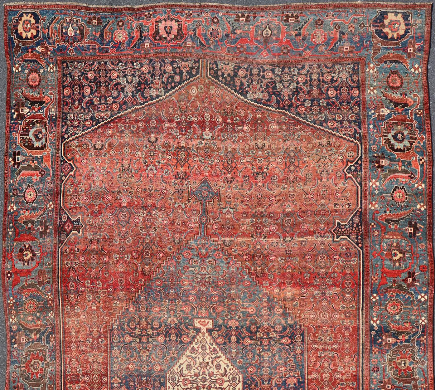 Bidjar classique en terre cuite et variété de beaux tons rouges, encadré par des nuances panachées de couleurs bleues dans la bordure avec des géométries à grande échelle. Tapis ancien Bidjar de Perse à motifs de médaillons, tapis V21-0106, pays