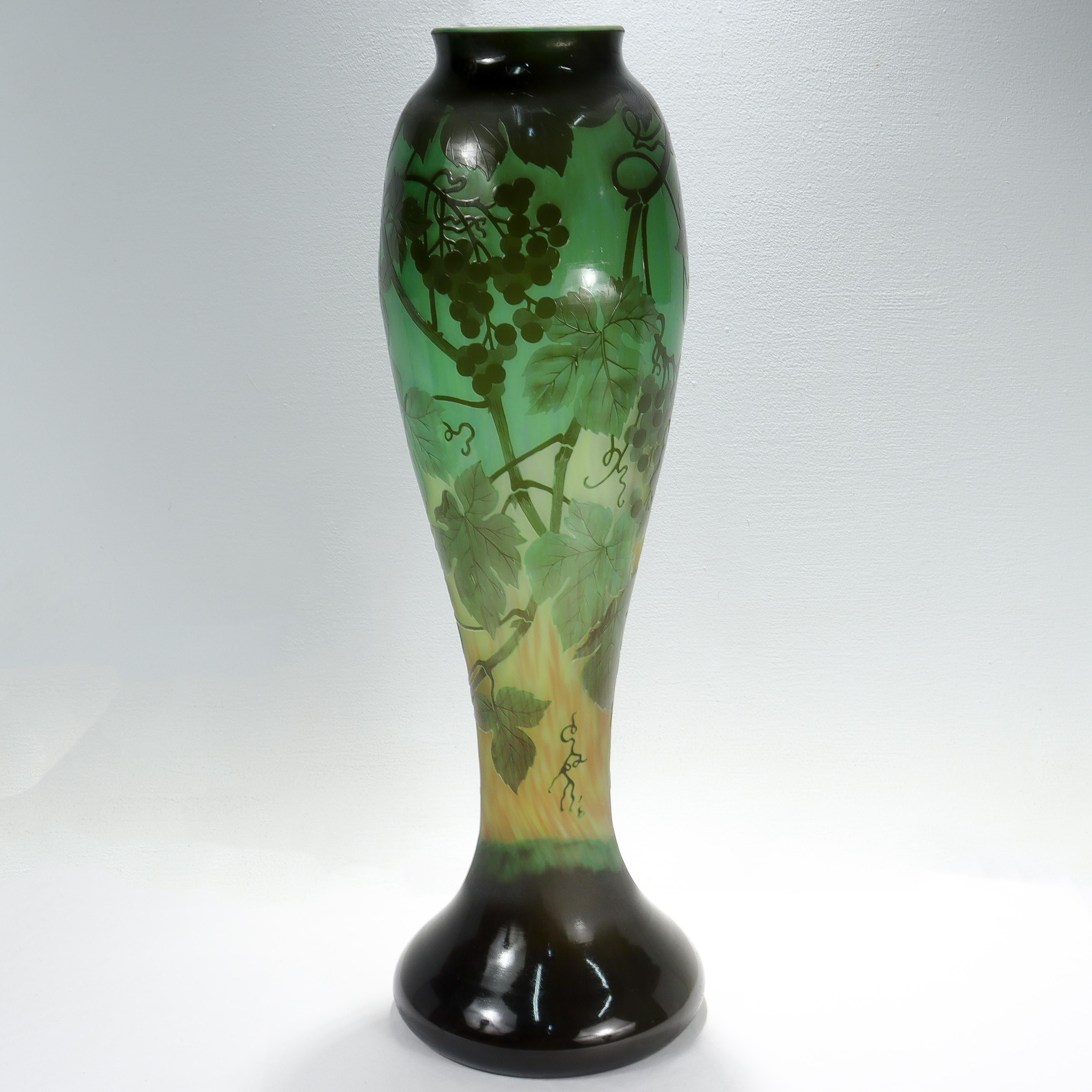 A fine, very large scale antique French art glass vase.

In green tones.

With acid-cut back cameo grapes, grape leaves, & vines.

Signed 