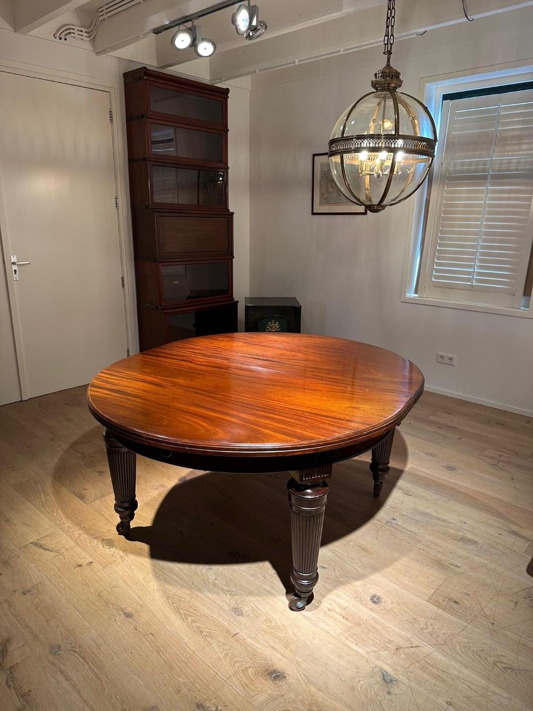 Very large antique English oval table with 5 original leaves, completely in perfect condition. Stylish leg. Unique and very solid antique dining table / conference table. The table has a double swivel mechanism with which you can turn the table