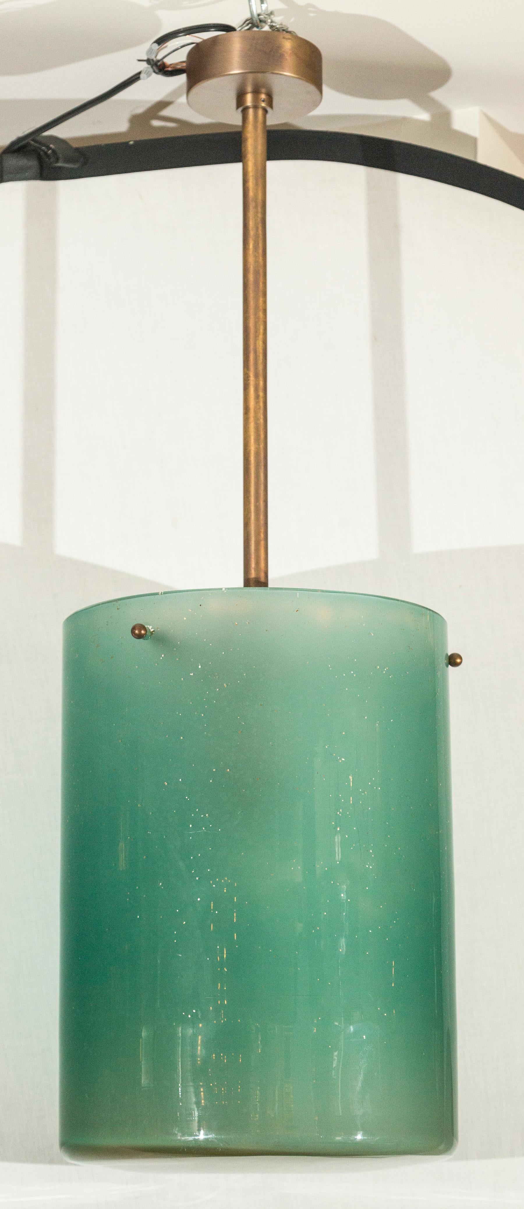 Two unique large blown jar style pendants/ lanterns in a ever changing aqua fume color speckled with gold and silver mica to create an organic modern effect
Hardware in a rustic dark antiqued brass finish
Note each glass weighs 44lbs and this is