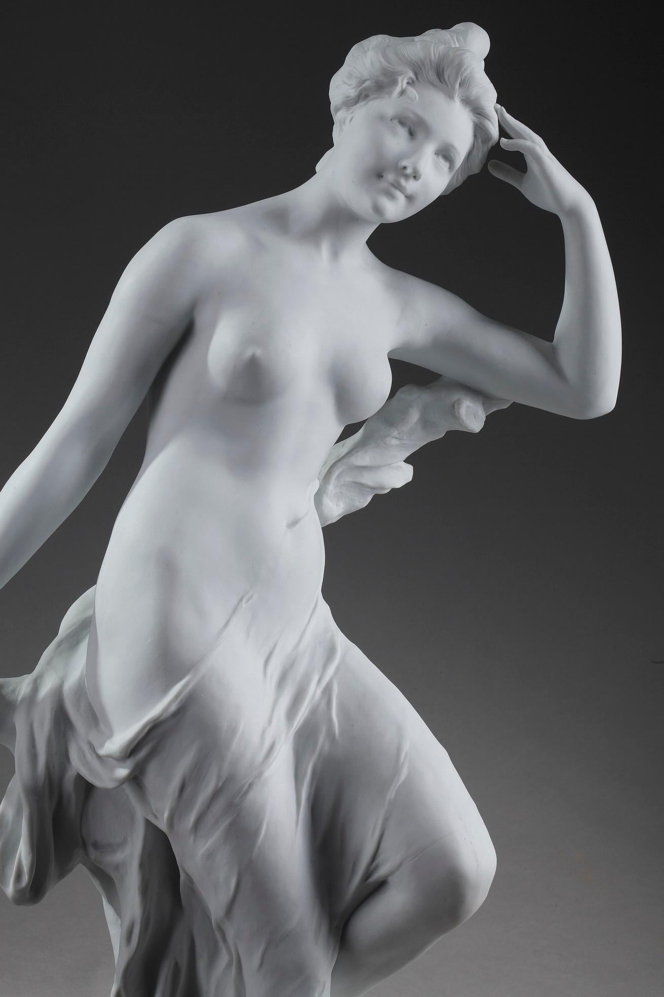 Very large Art Nouveau bisque statue featuring a young bather standing against a tree. The girl is almost naked. The drapery that closely follows the forms of her body and creates small folds is inspired by antiquity. The nymph's idealized body, her