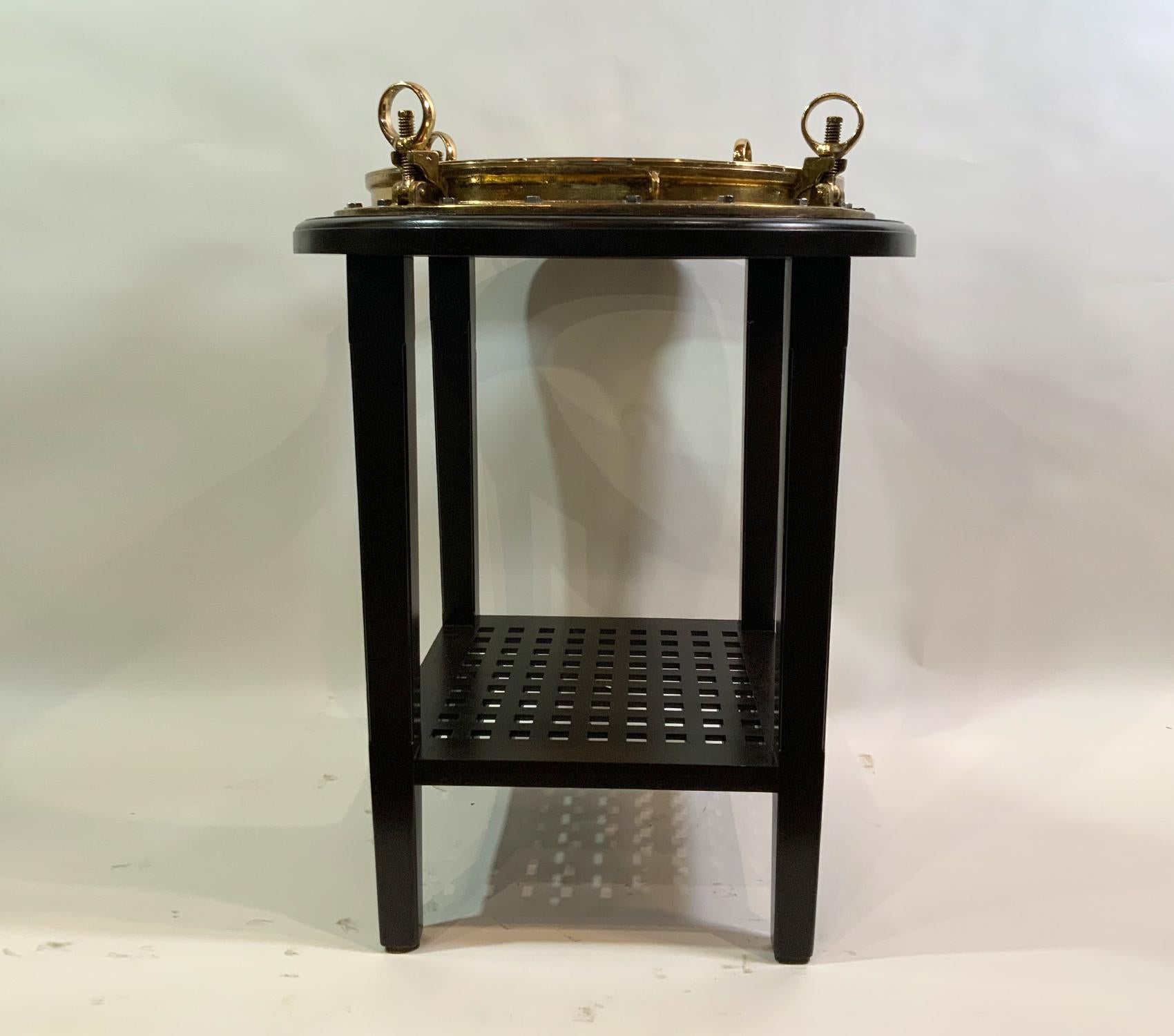 Ships porthole of enormous size converted to a bar height bistro table that will fit four stools. Three feet overall diameter. Custom mahogany table with ships grating shelf. This is a statement piece.

Weight: 117 LBS
Overall dimensions: 39” H x