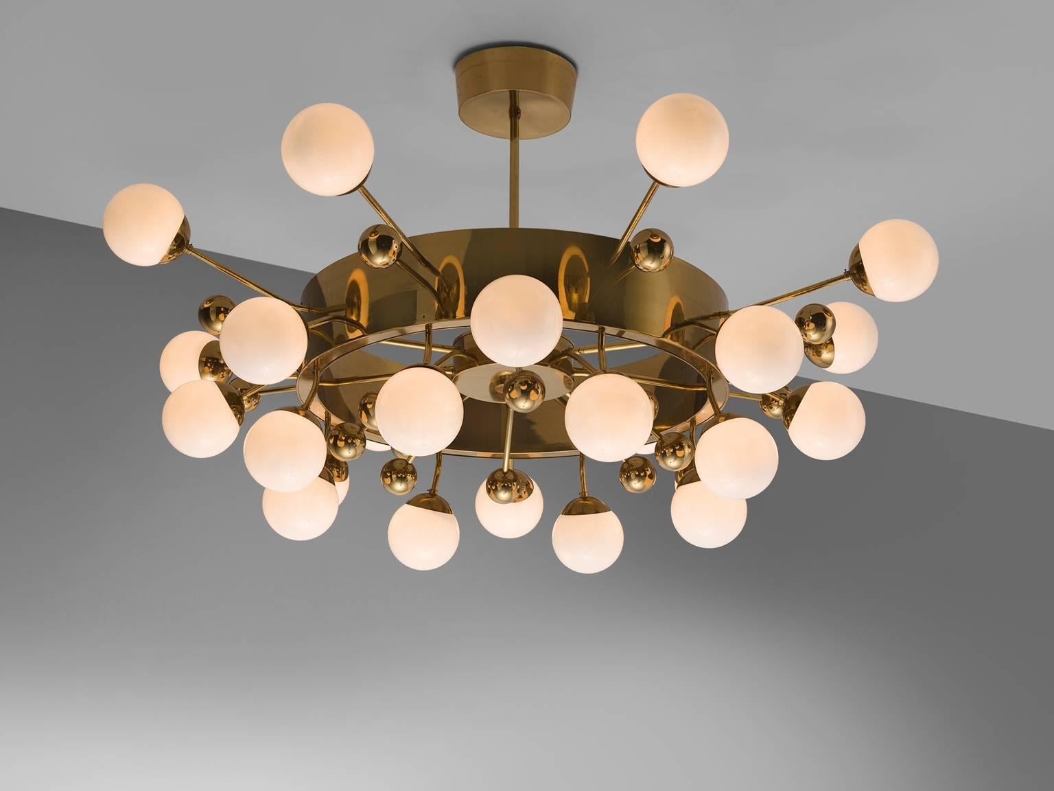 Large 2.2 mt / 7.2 ft sputnik chandelier, in glass and brass, Europe, 1960s.

This grand chandelier is executed with a brass fixture and 24 opaline glass spheres. The chandelier exists of two layers of glass bulbs amongst which brass globes are