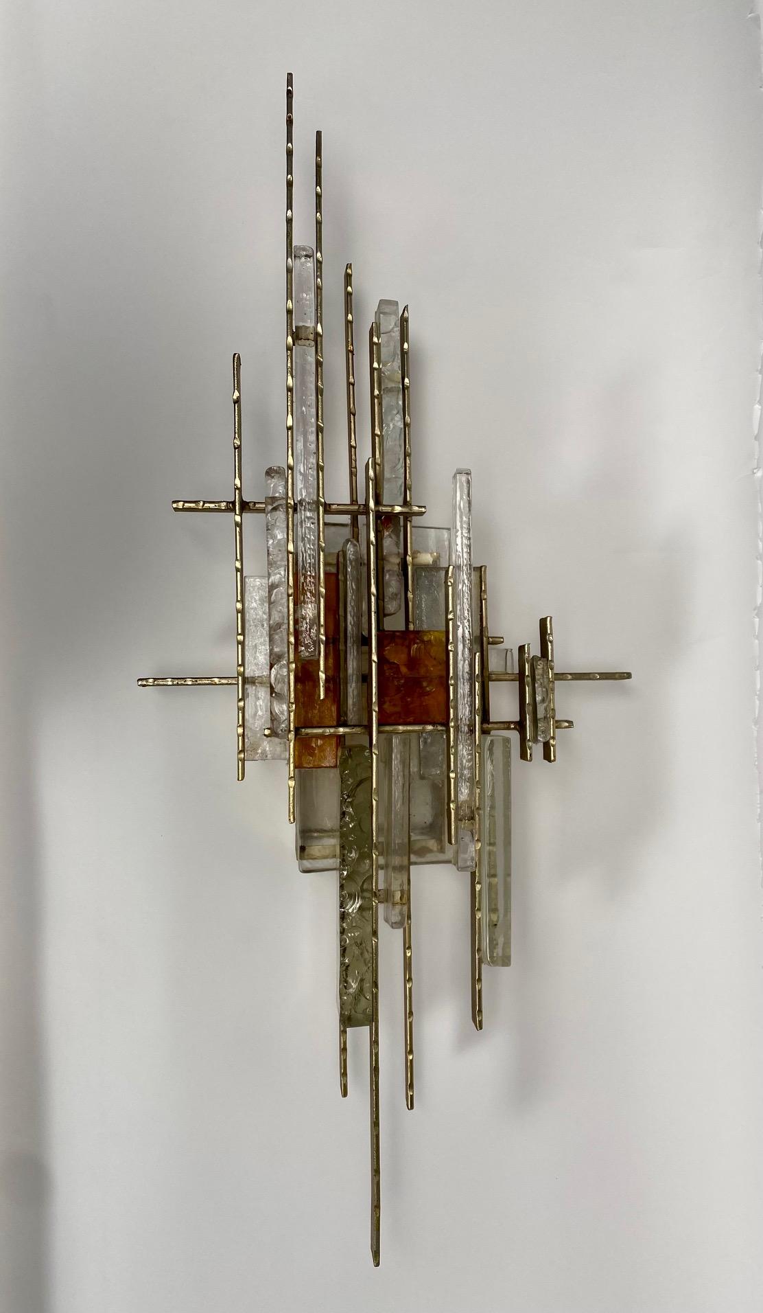 Very large brutalist wall light by Albano Poli for Poliarte, Italy 1970s

A sculptural wall lamp, of considerable size, handcrafted by assembling transparent and colored glass (amber), and metals, giving life to a precious brutalist composition.