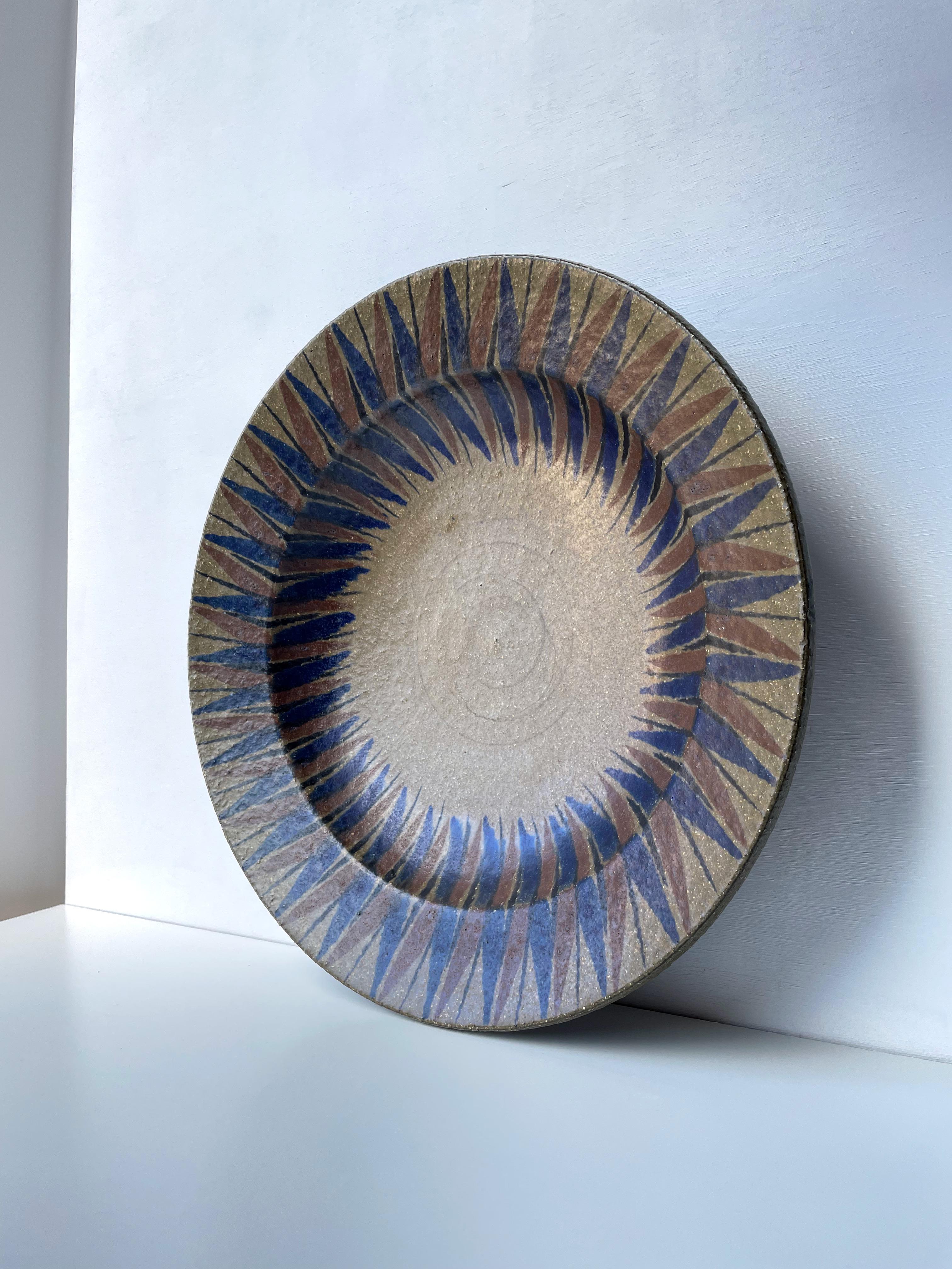 Very large, stunning Nordic decorative hanging wall plate / centerpiece / bowl in muted earth tones. Peanut brown matte glaze with navy blue and cinnamon brown sharp lined graphic pattern along the sides. Raw, hickory brown stoneware on the back.