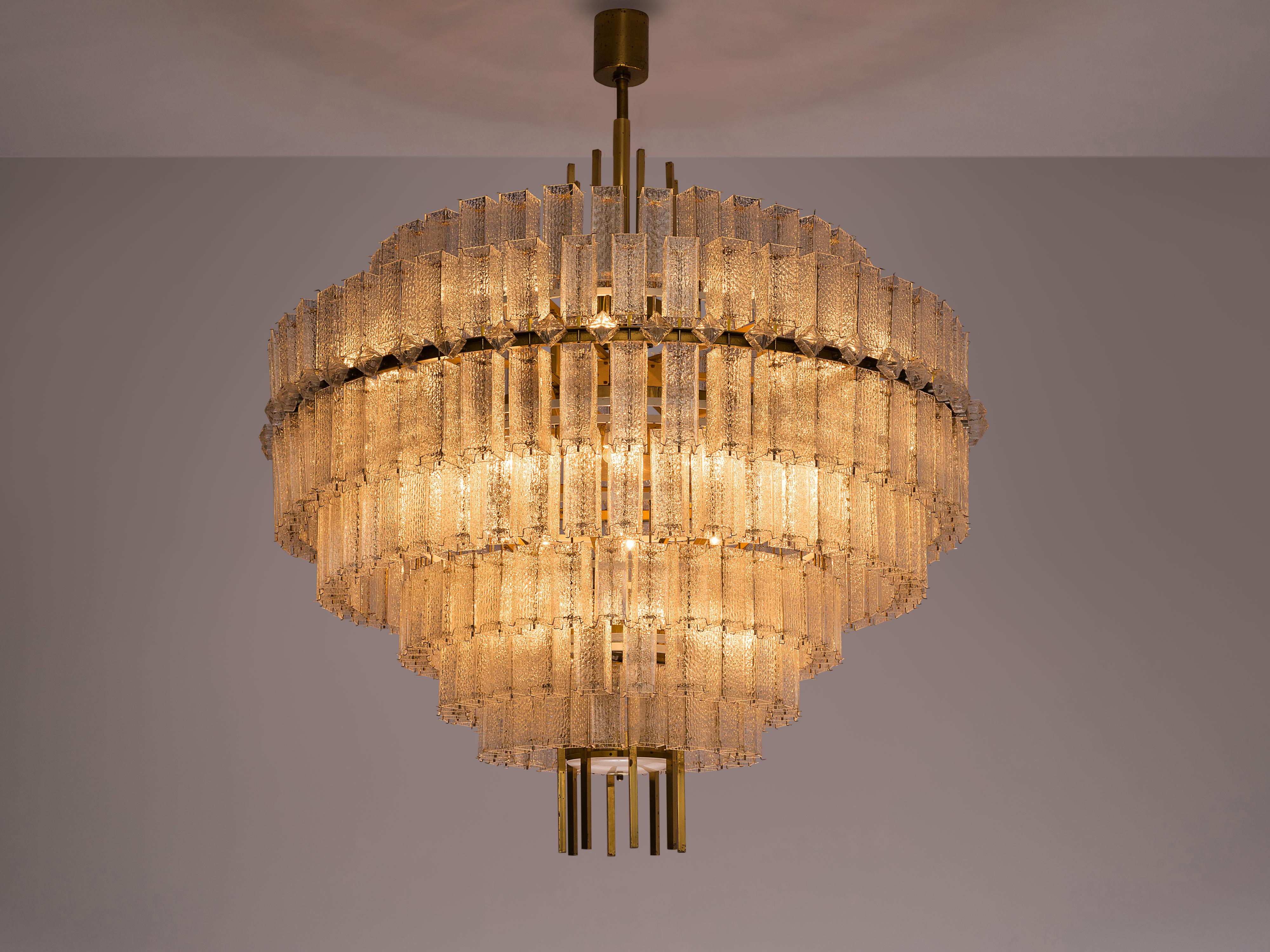 Large chandelier, glass, brass, Europe, 1970s.

Large circular 200 cm/6.5 ft chandelier with seven layers of glass shades. The frame is made of brass and holds numerous structured glass 'tubes' with a brass centre. Due to the combination of the