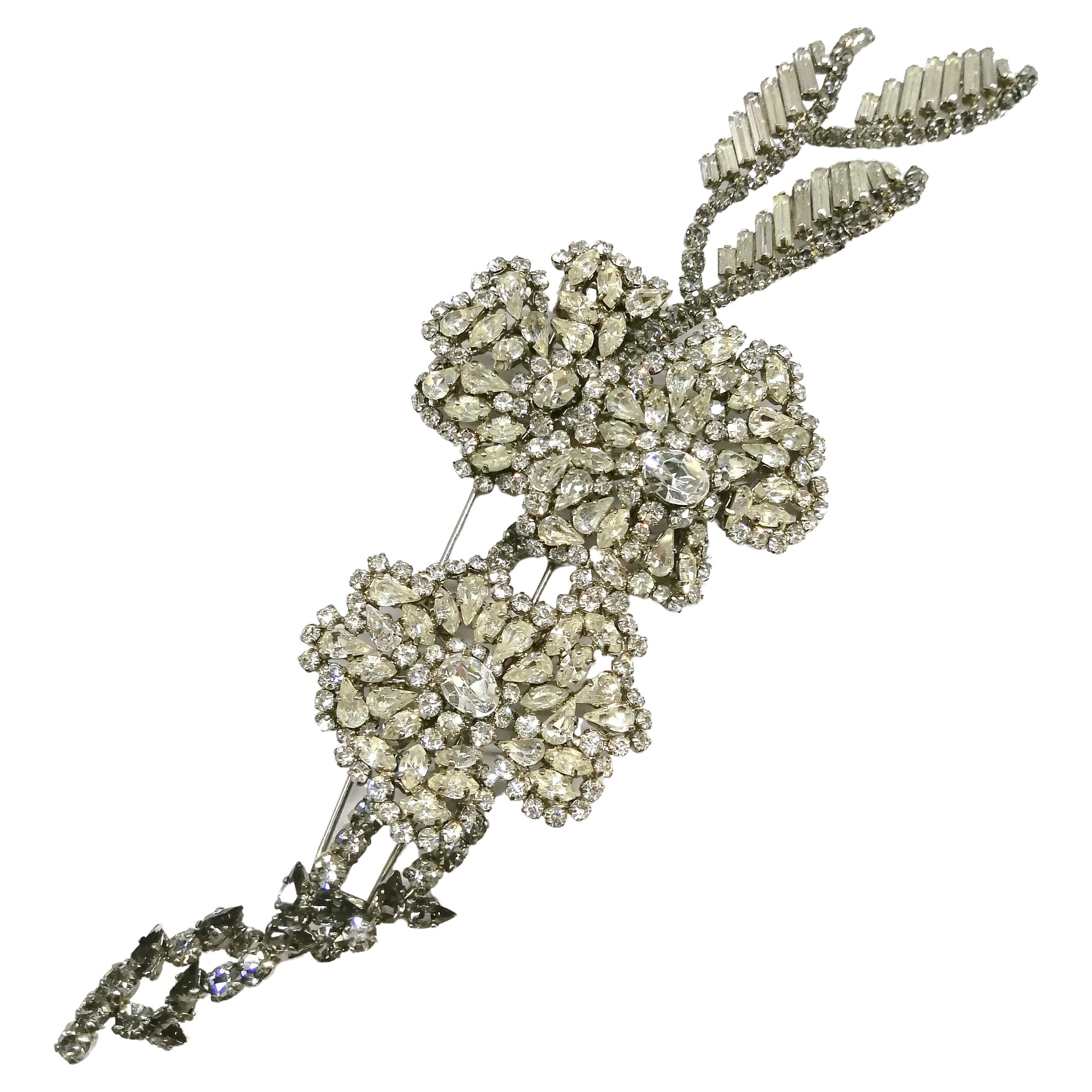 An outstanding and very rare, extremely large brooch by Roger Jean-Pierre. The subtle combination of clear and smokey grey pastes give the brooch a three dimensional quality, and contrast to the brooch. Two full blossoms of clear paste are in the