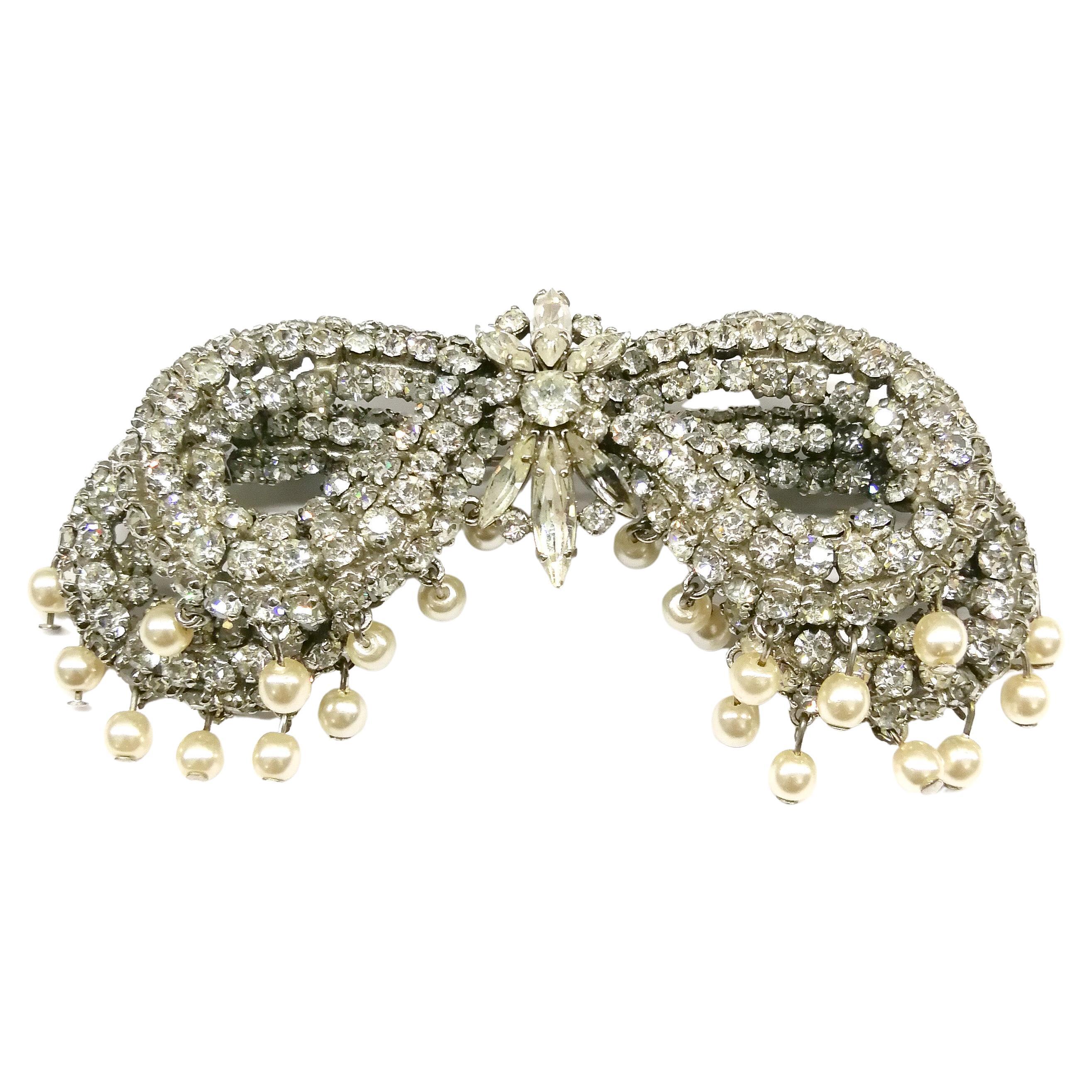 A rare and large 'bow' brooch by Roger Jean-Pierre, with the stones set, and the familiar structure characteristic of Roger Jean-Pierre. Fringed with 'en tremblant' cream barogue pearls, the brooch is very three dimensional, highly reminiscent in