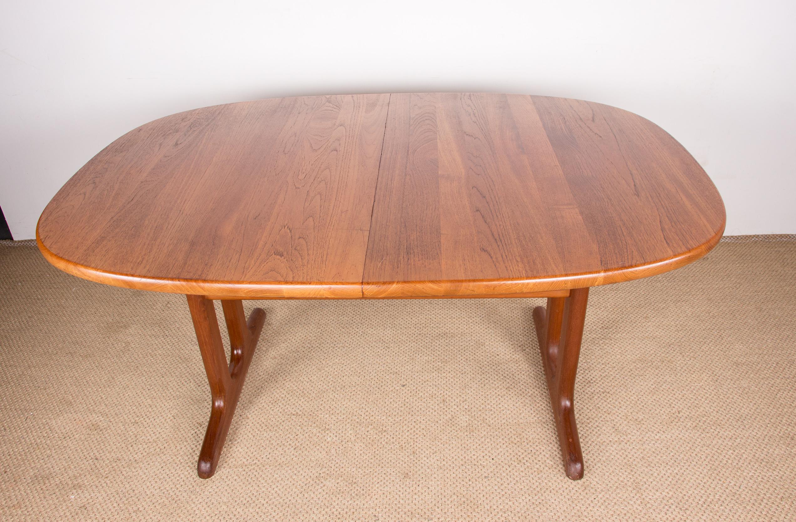 Beautiful Scandinavian dining room table in solid teak. 
Oval in shape with a double central base, it has 2 large extensions to accommodate 10/12 people. 
Robust construction of good quality, functional furniture ideal for large tables.
Length: 153,