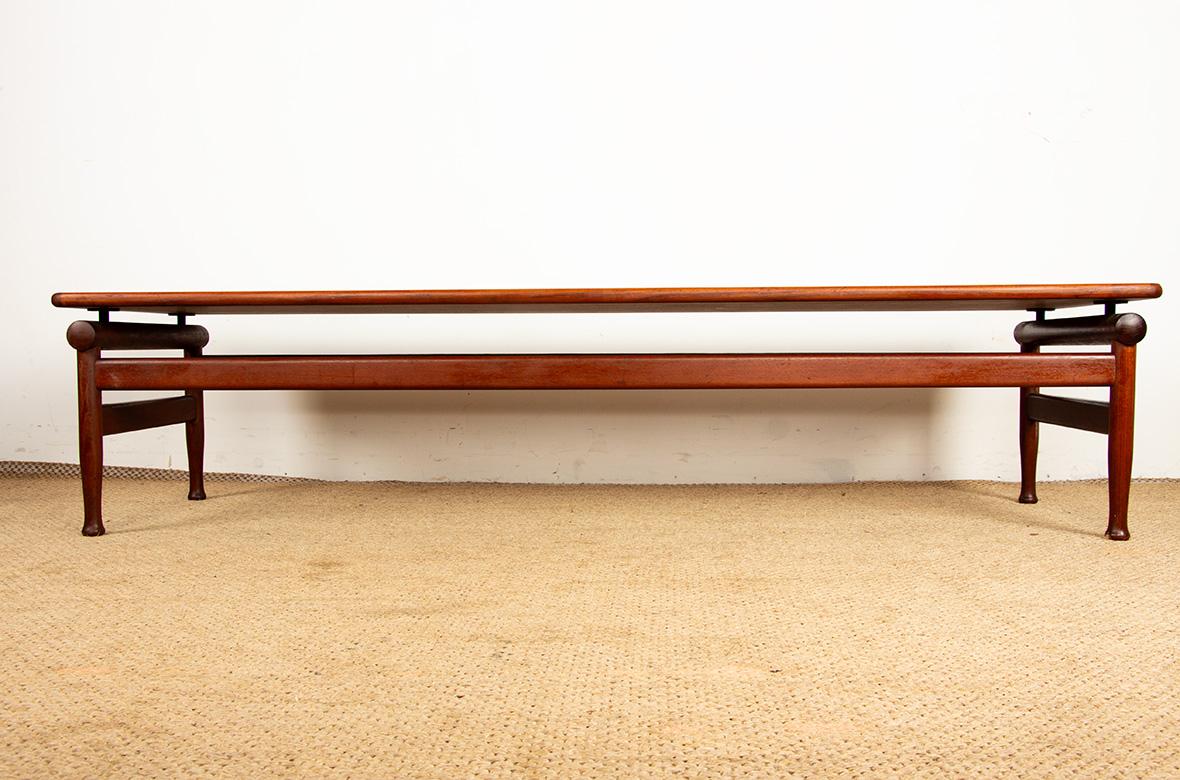 Un magnifico tavolino o panca scandinava di grandi dimensioni. Due grandi traverse strutturano il tavolo. Le gambe laterali arrotondate, sostenute da supporti in metallo spazzolato fissati al piano, conferiscono grande eleganza a questo tavolo di