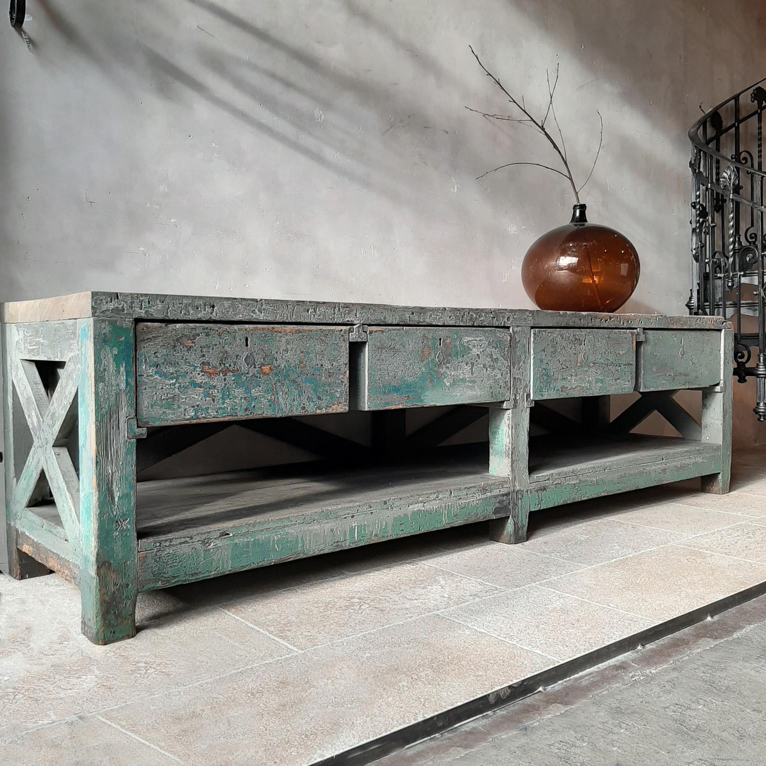 Very large Dutch workbench from the 1950s with original old paint remnants. A beautiful and very strong pine construction with diagonal crosses and 4 deep drawers. This workbench with original old green patina remains can beautifully serve as a