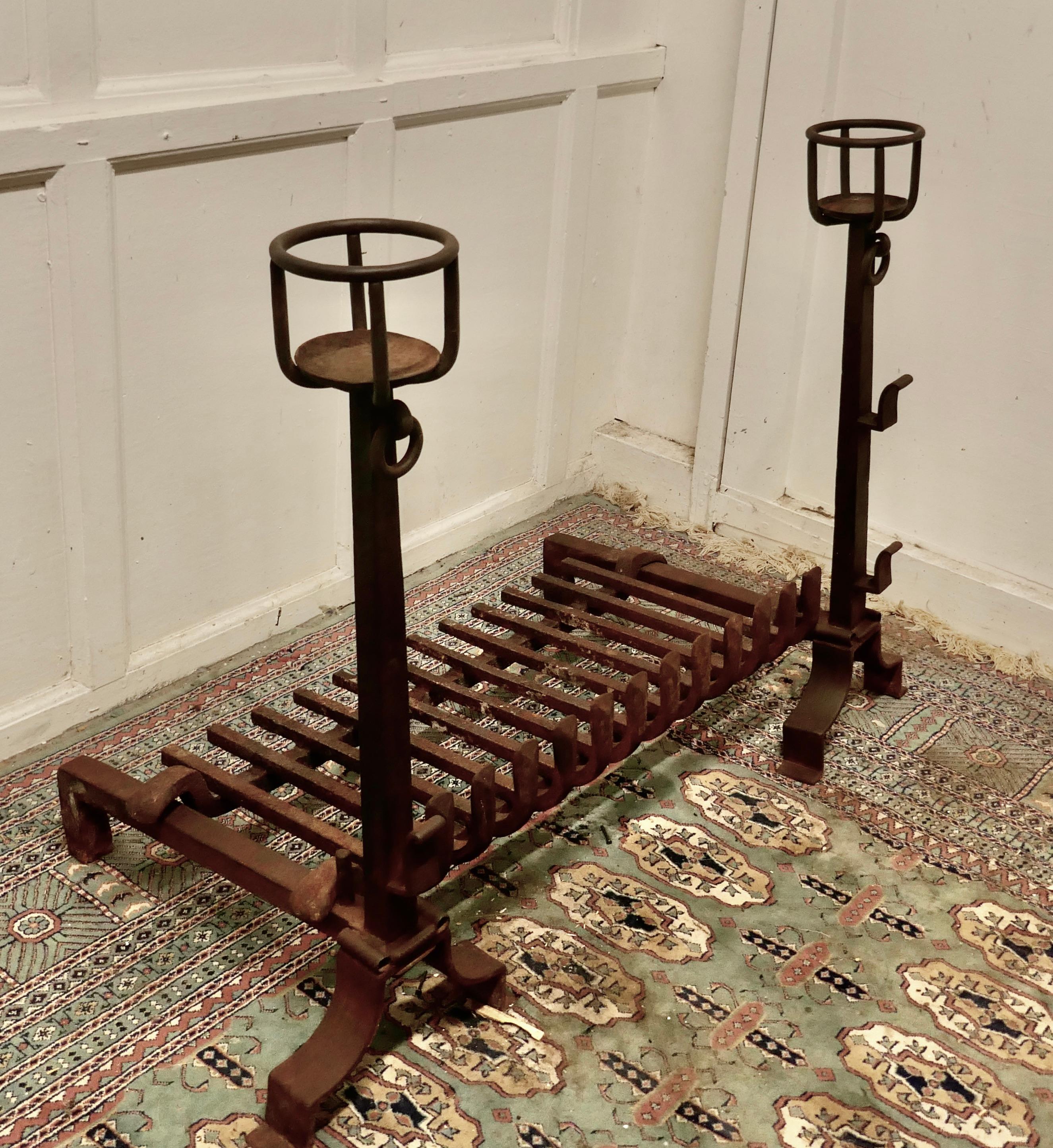 Very large early 19th century French fire grate set on iron andirons

This is a very large fire grate set on tall bowl Andirons, they are Blacksmith made with bowls to the top and spit rod carriers on the front, needless to say these are very