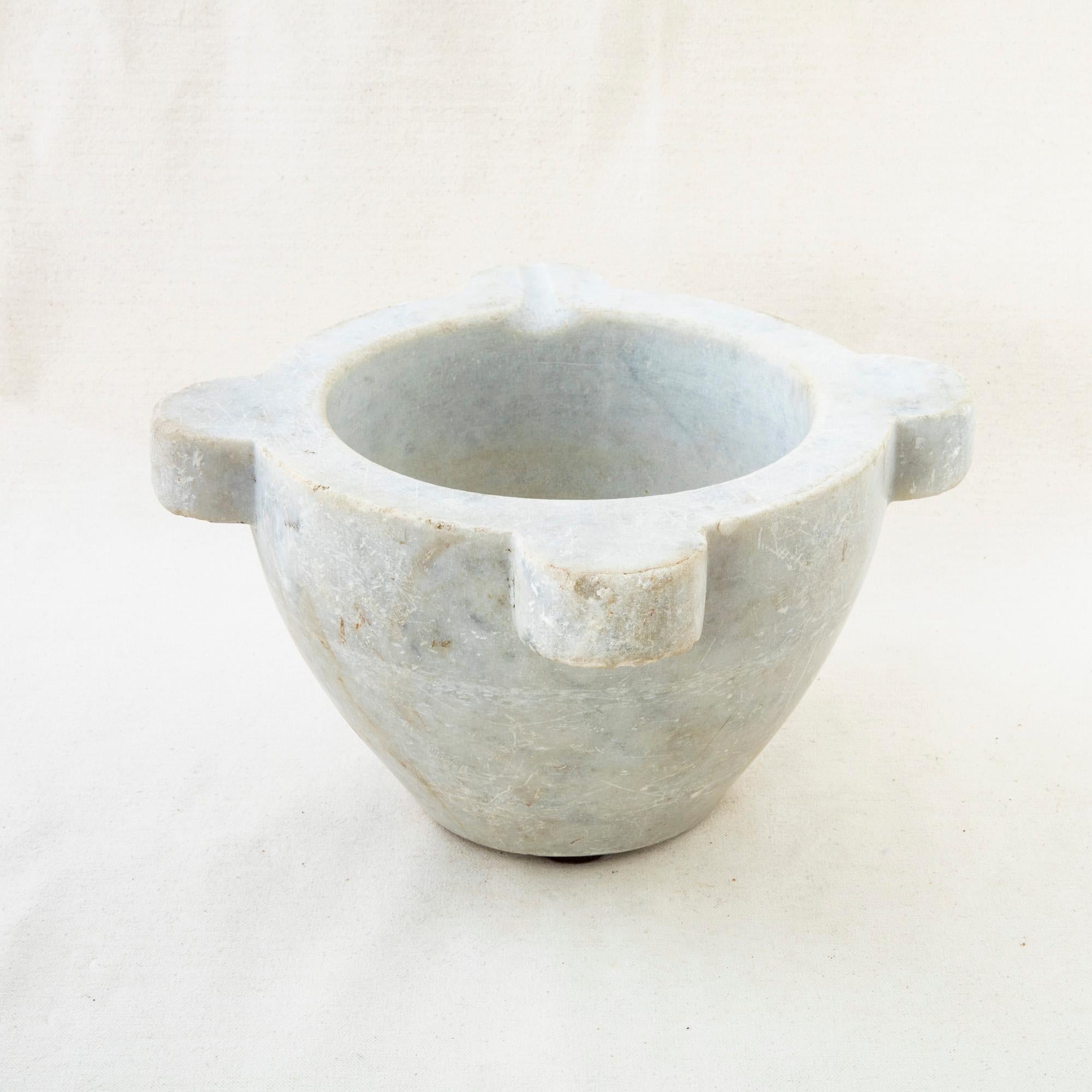 This large carrara marble mortar from the turn or the 20th century is made from a single block of unpolished marble. Once used to grind herbs, it can now serve as a planter, bowl, or vase and is conducive to both indoor and outdoor use. It would