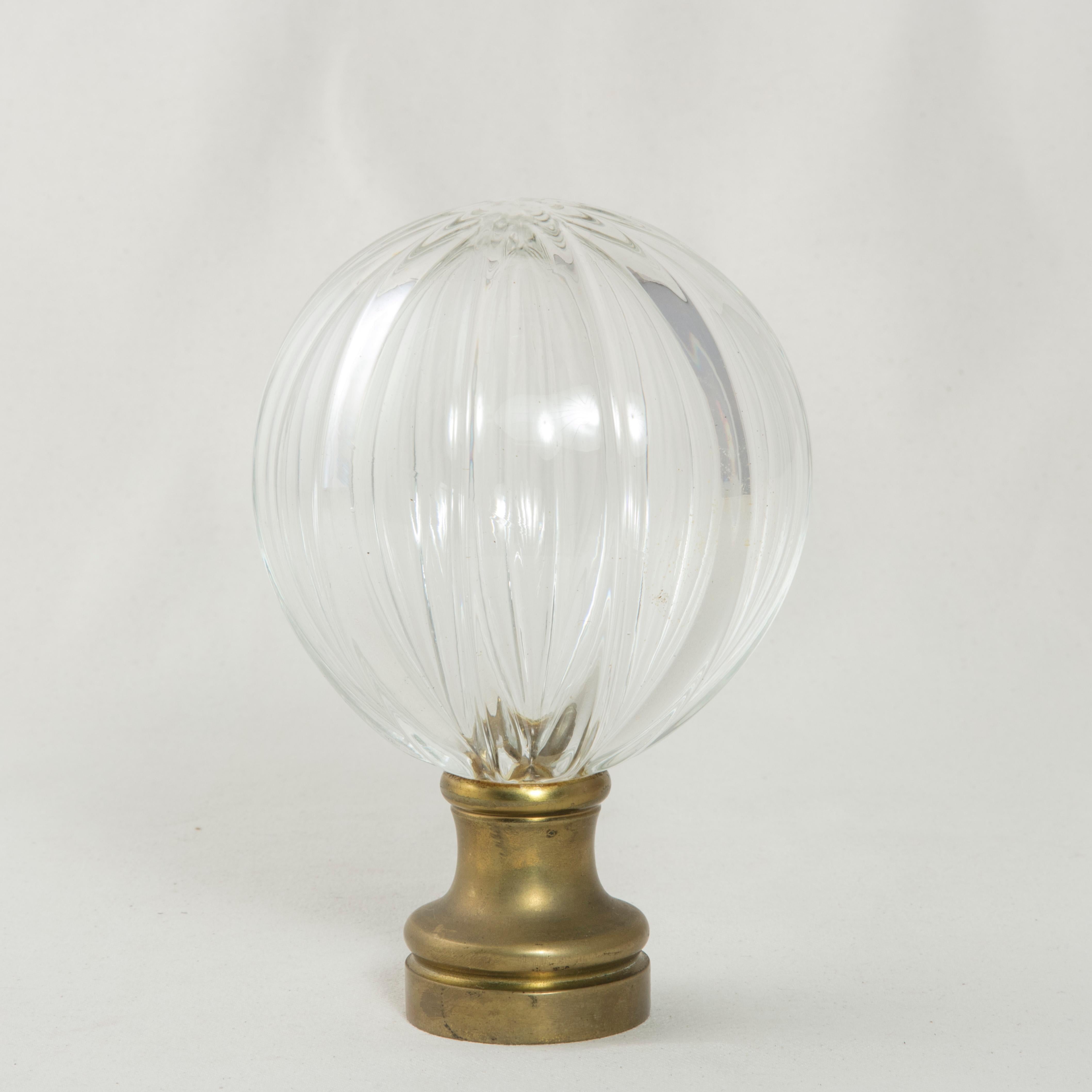 This very large early 20th century French Art Deco period staircase finial features a multifaceted crystal ball mounted on a brass base. The base is threaded to screw onto a staircase banister for secure attachment. Standing at almost seven inches
