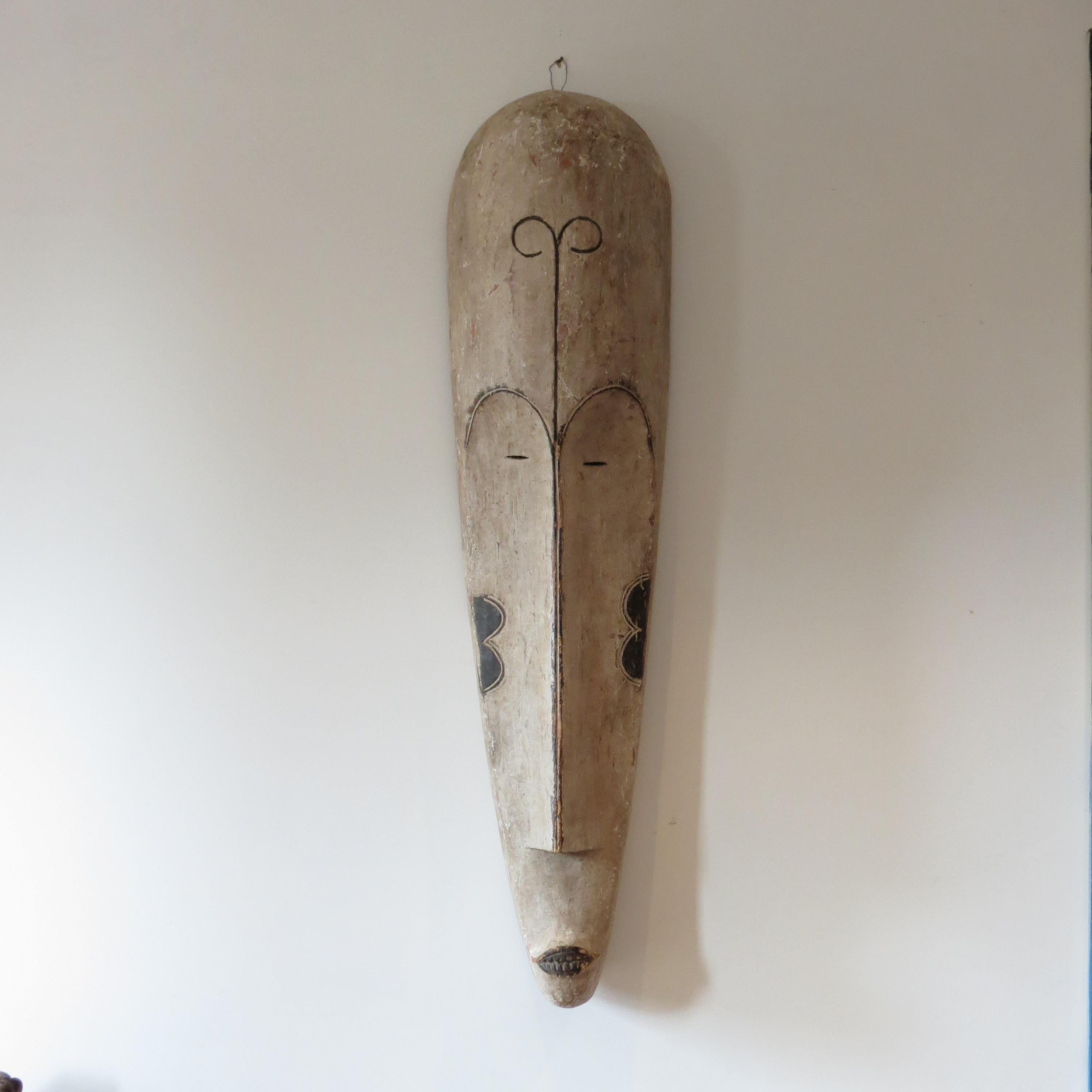 A wonderful, very large elongated Tribal fang mask from Gabon. 
Hand carved and hand painted using tempura paint. 
Used in ceremonies, the mask has very nice detail to it and makes a striking wall hanging.  
Holes to the edge of the mask would