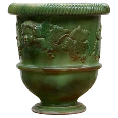 Jardinera muy grande de terracota esmaltada decorada con caras y hojas de vid