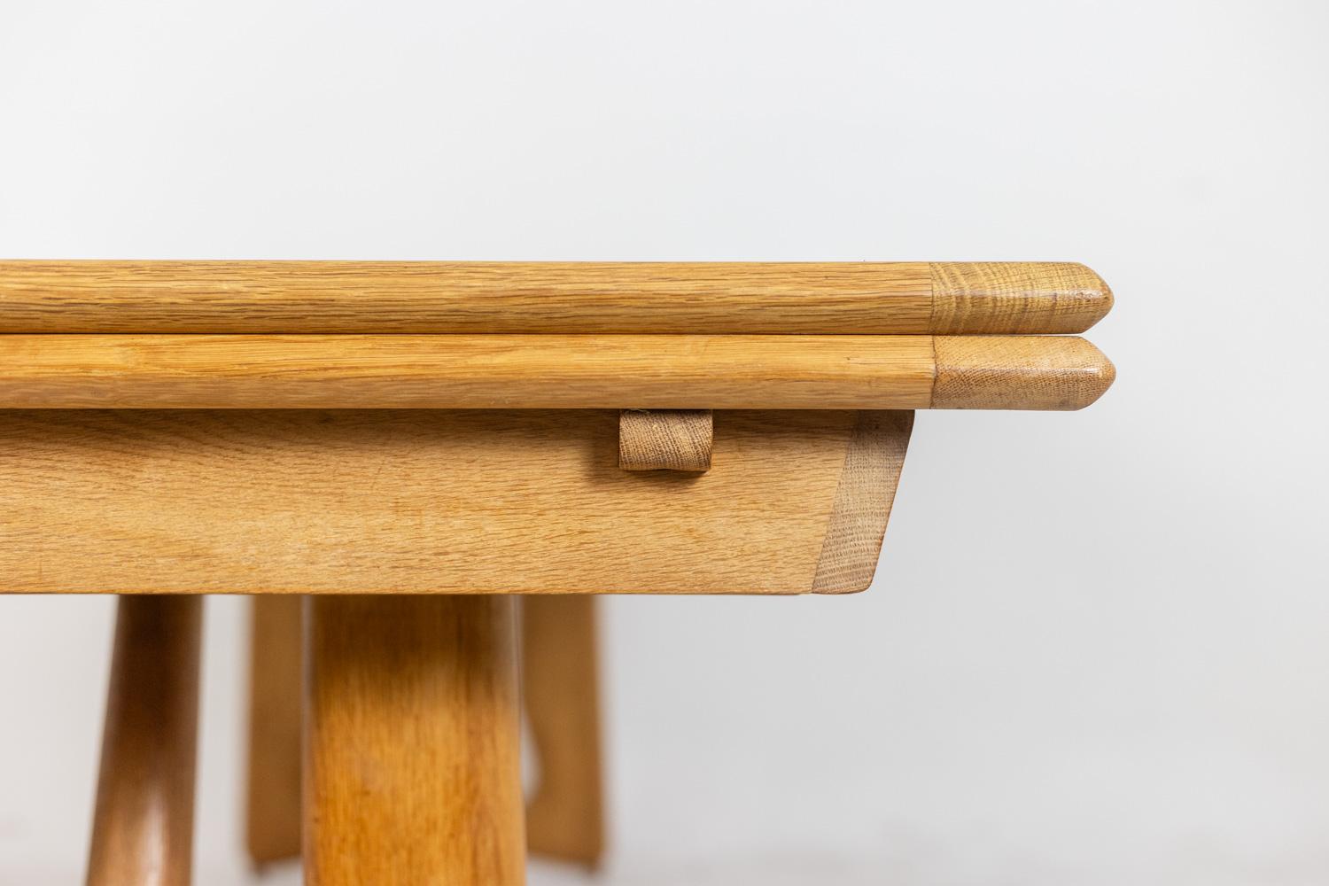 Très grande table de salle à manger avec ses 2 rallonges elle peut accueillir 14 personnes. Il est fabriqué en chêne blond naturel et comporte quatre grands pieds avec un retour de type entretoise et des formes incurvées. Il s'agit sans aucun doute