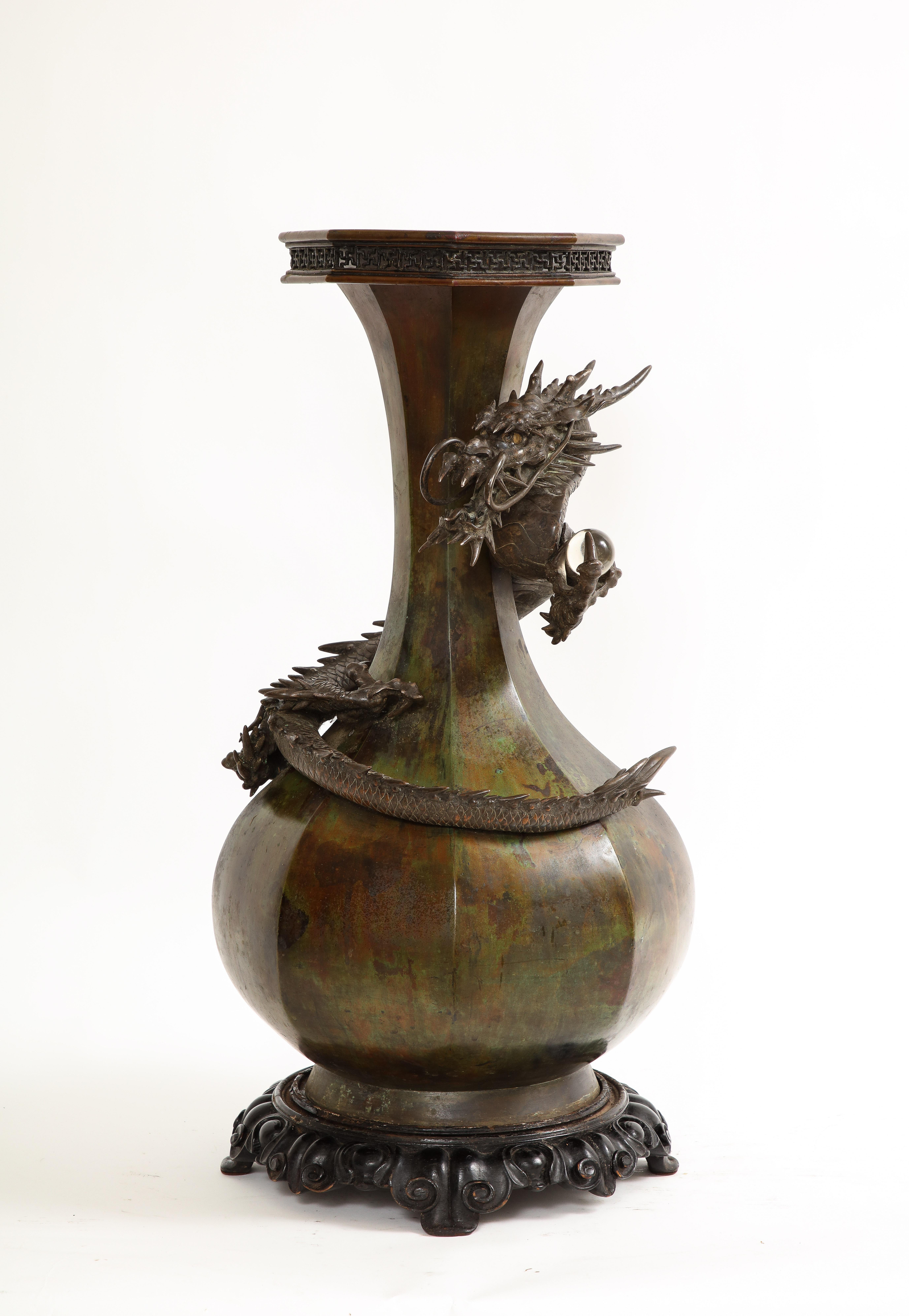 A Fantastic Japanese Meji Period Patinated Bronze Dragon Vase.  This vase is both elegant and awe-inspiring specifically for its Size and shape. The very large vase is wrapped around with a Ryu dragon that is entwined in high relief and with great
