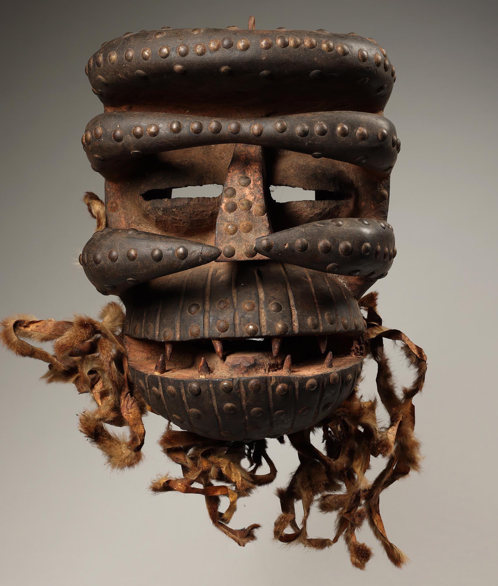 Très grand masque féroce Dan Guere ou We de la Côte d'Ivoire Afrique ex collection Fearing. 
Masque solide avec des yeux fendus en retrait, des défenses en bois sculpté en saillie qui encadrent le visage, une grande bouche ouverte avec des dents et