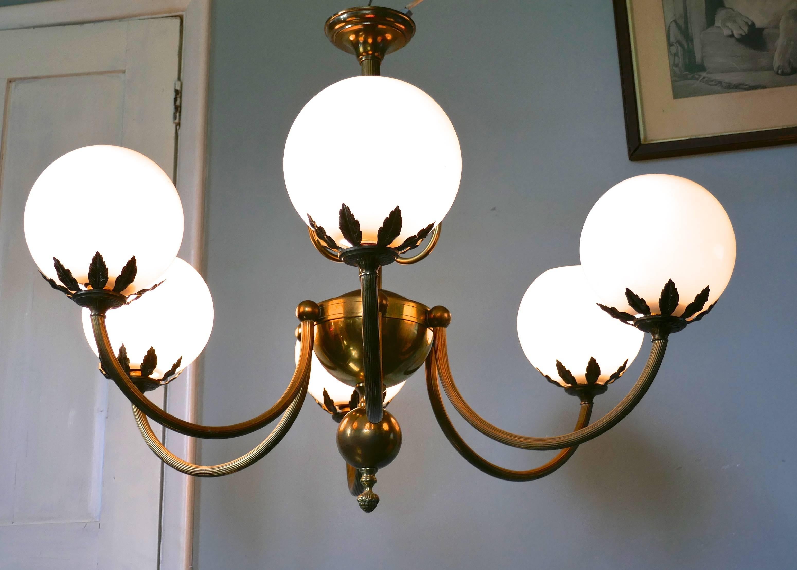 Very large French Art Deco six branch globe chandelier 

This is a very large piece, the six branch brass frame has large bulbous centre piece and the lamp holders are decorated with brass leaves to adorn the white glass globes
The lamp is in