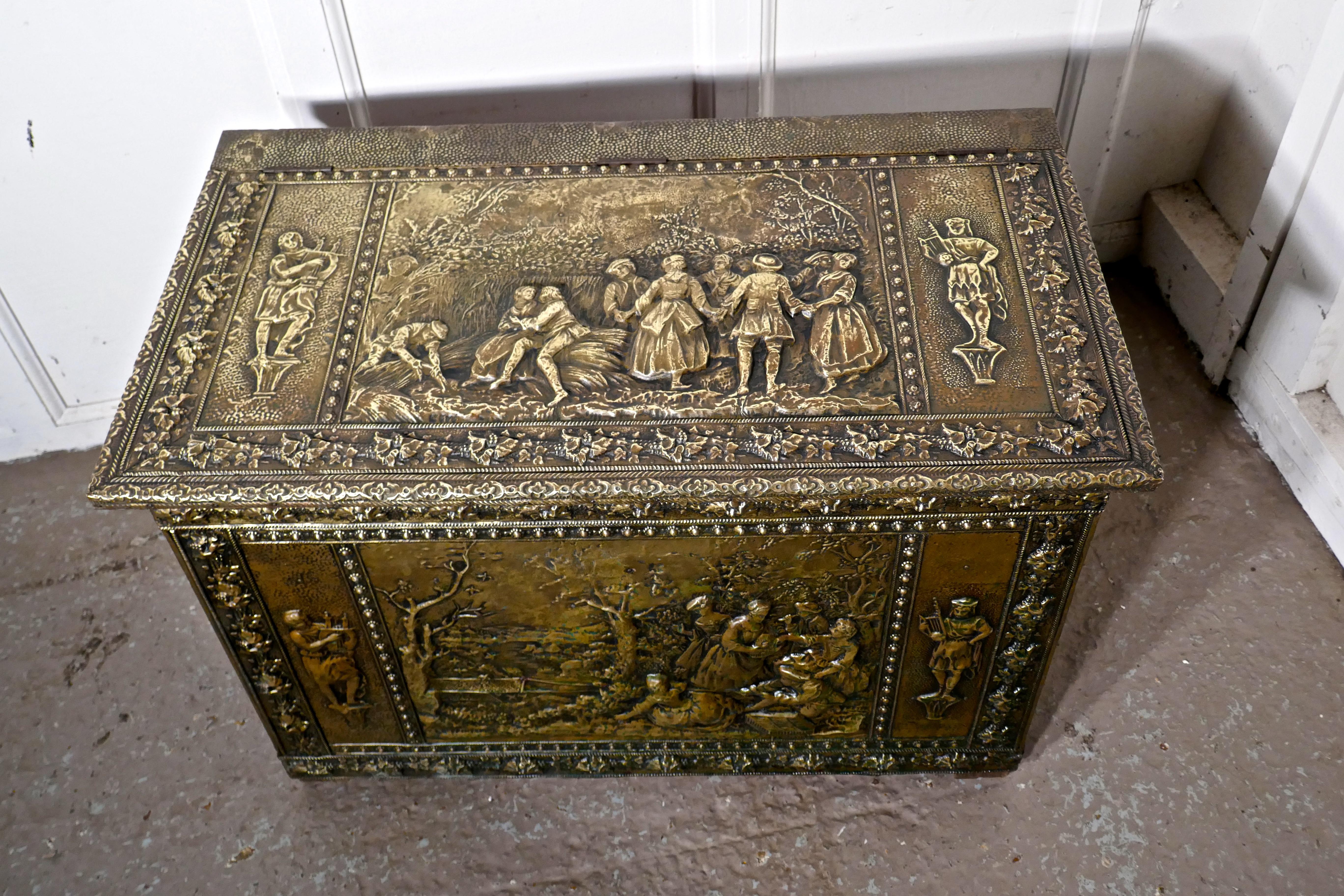 Very large French embossed brass log box, with country scenes

This is a large chest is made in brass with a wooden lining, the beaten brass is embossed with country scenes celebrating the harvest on the top and front, on the sides the scenes are