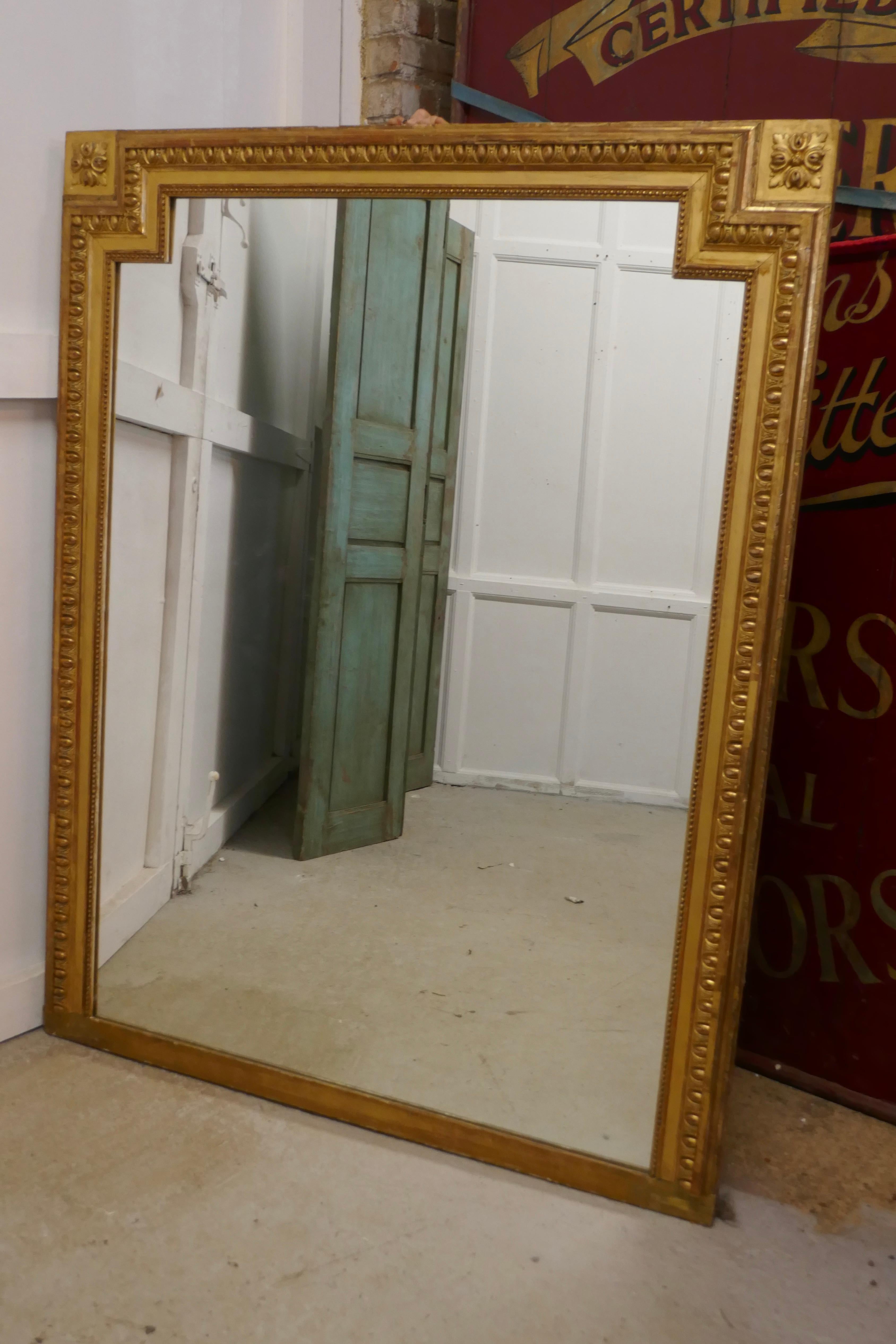 Very large French gilt over mantel (fireplace) mirror

The over mantel as it name implies was made to sit over the mantel piece and as so many fireplaces are opposite the window mirrors were used to reflect more light into the room
The old gold