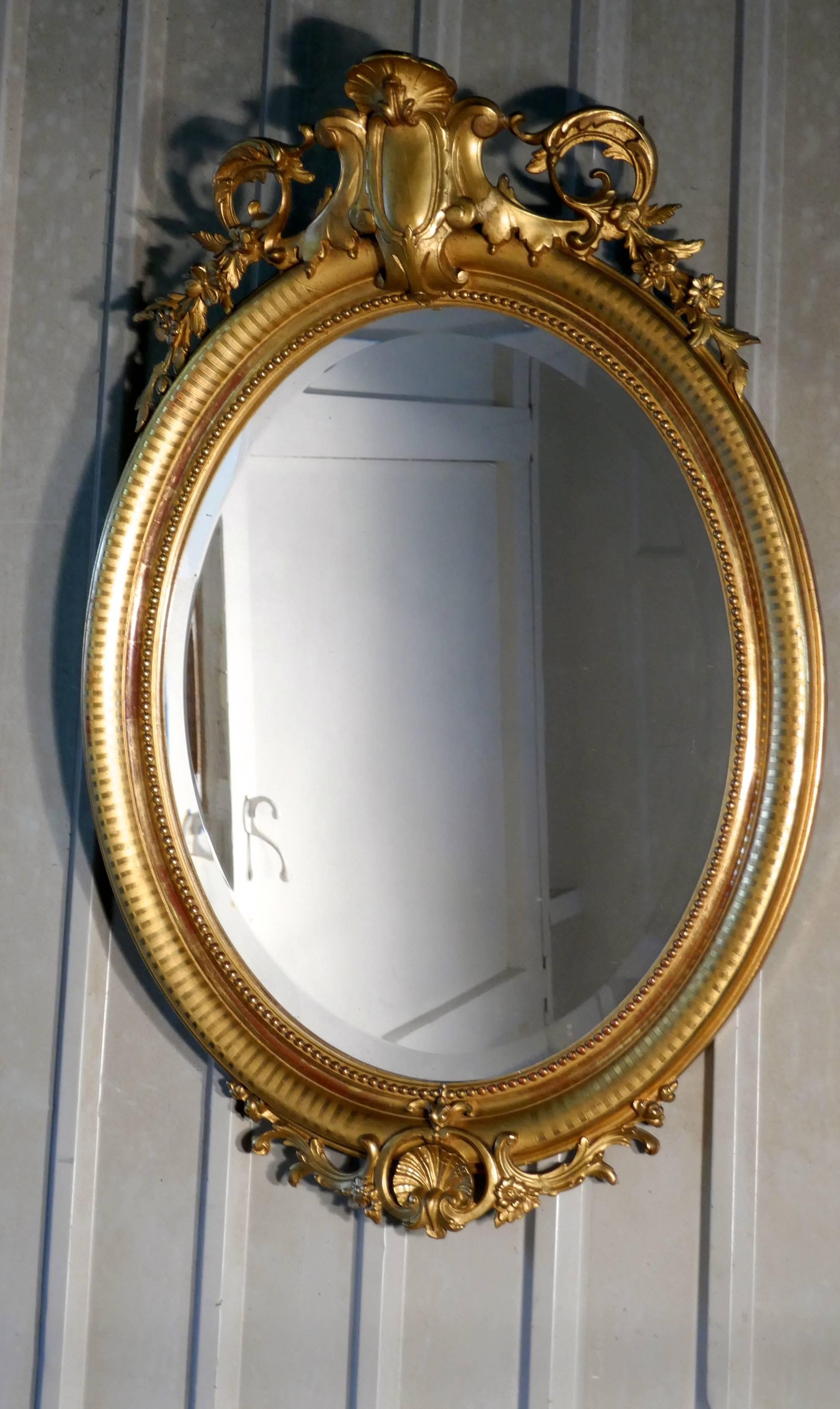 Un très grand miroir mural Rococo français ovale et doré

Le miroir a un cadre doré exquis dans le style Rococo, il est décoré de coquillages, de guirlandes et de feuilles avec une bordure à motifs attrayante
Le grand cadre ovale est fait de