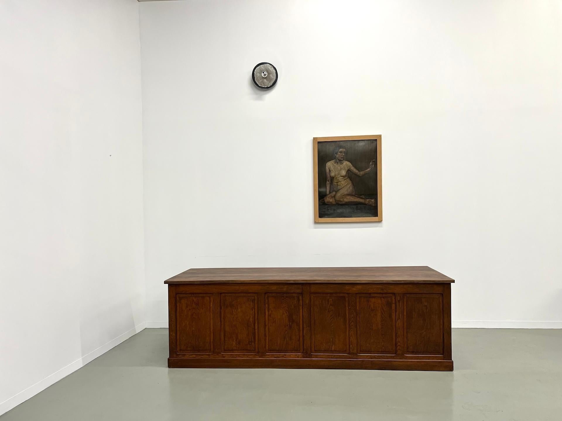 This sublime trading counter from the 1900s in solid oak in XXL format, which can also be used as a very large desk, is superb. With its original patina, we have restored the top to give it a perfect finish. It is equipped with 11 very deep drawers