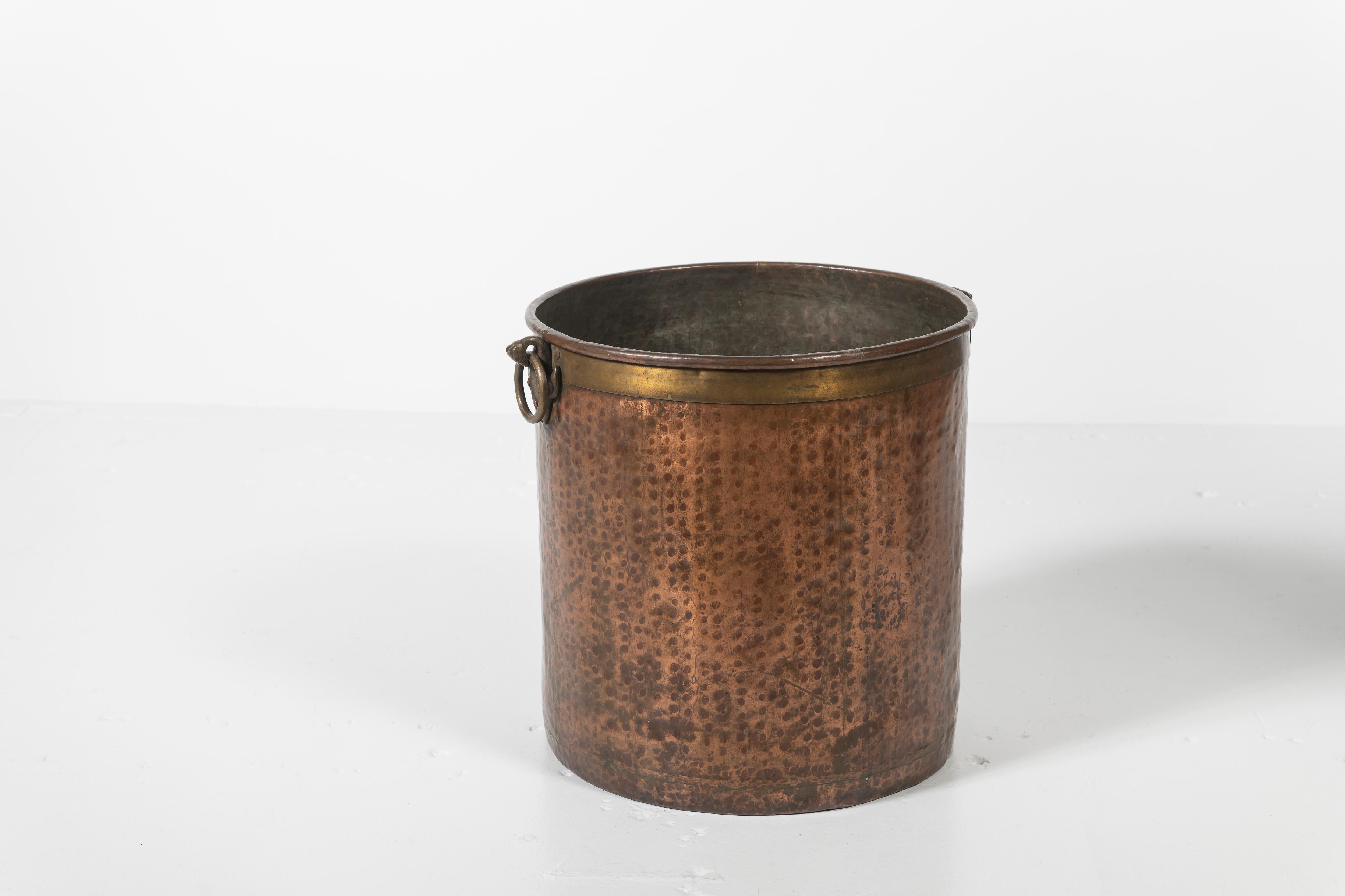 This hammered copper planter is perfect for a larger plant/tree or storage for wood/other items around the hearth and garden. It's in very good condition and is presumed to be of French origin, 20th century. Brass details and handles.
