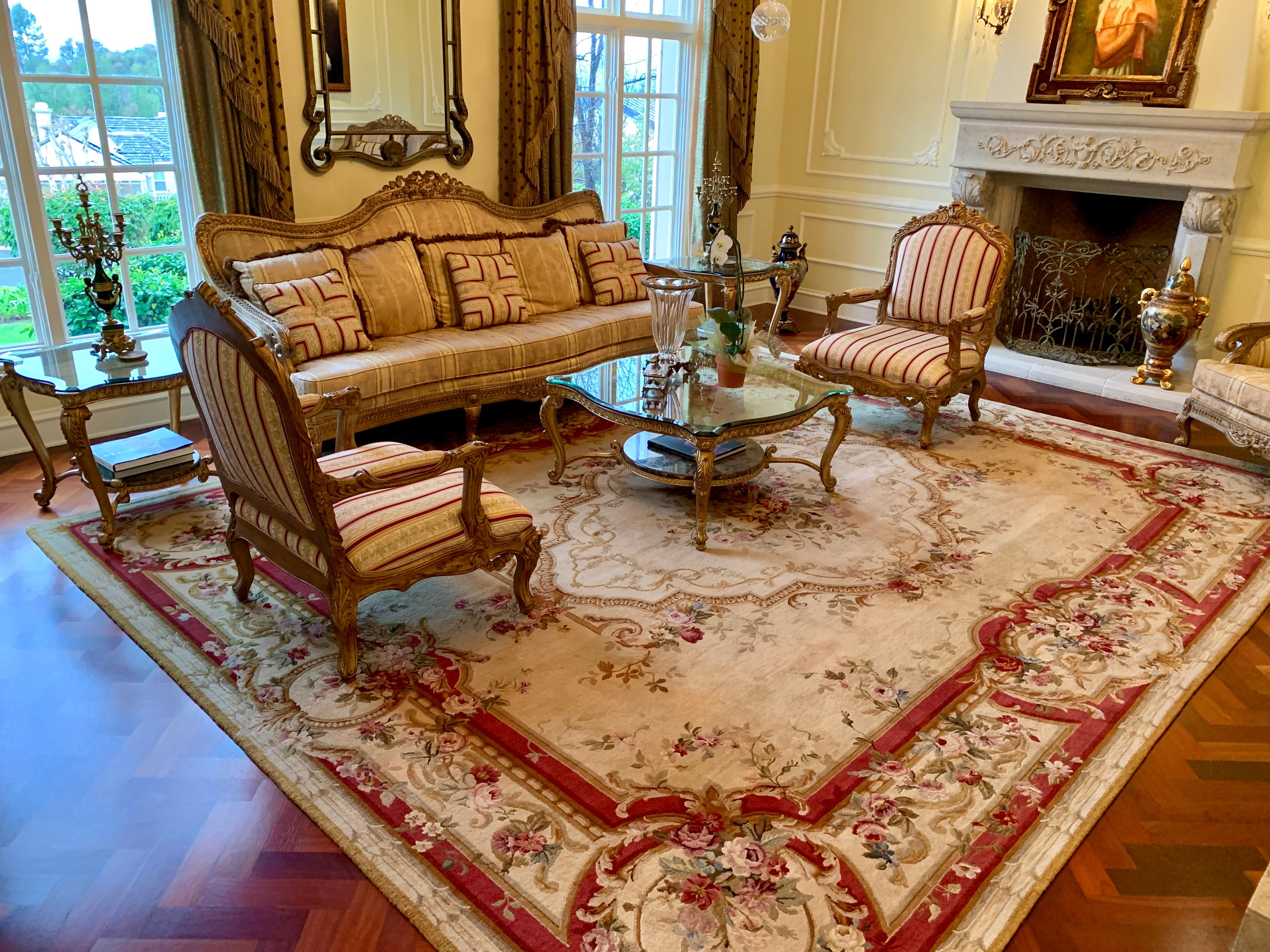 Very palatial, handmade, approximately 12’ x 15’, grand French Aubusson or Savonnerie style, estate wool rug with an ivory color background features rich floral toned bouquets and sprays of roses, as well as multicolored scrolling acanthus leaves